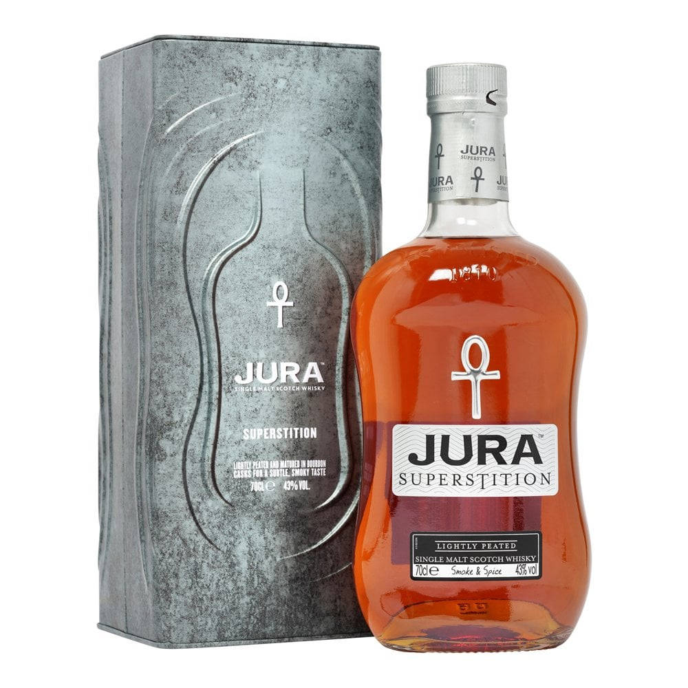 手機 桌布 壁紙 — 一瓶Jura Superstition單一麥芽威士忌，琥珀色液體，旁邊是帶紋理的銀色包裝，背景為白色。