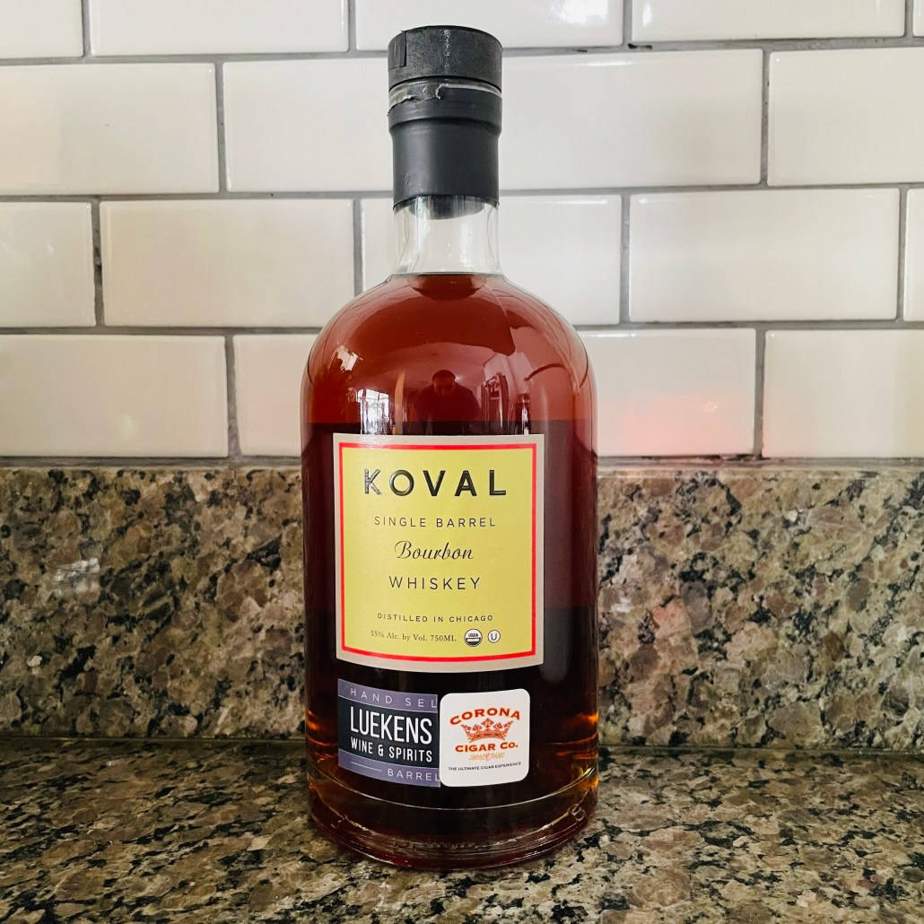 drinks 桌布 壁紙 — 一瓶Koval單桶波本威士忌放在帶有斑點的花崗岩檯面上，背景是白色地鐵磚防濺牆。