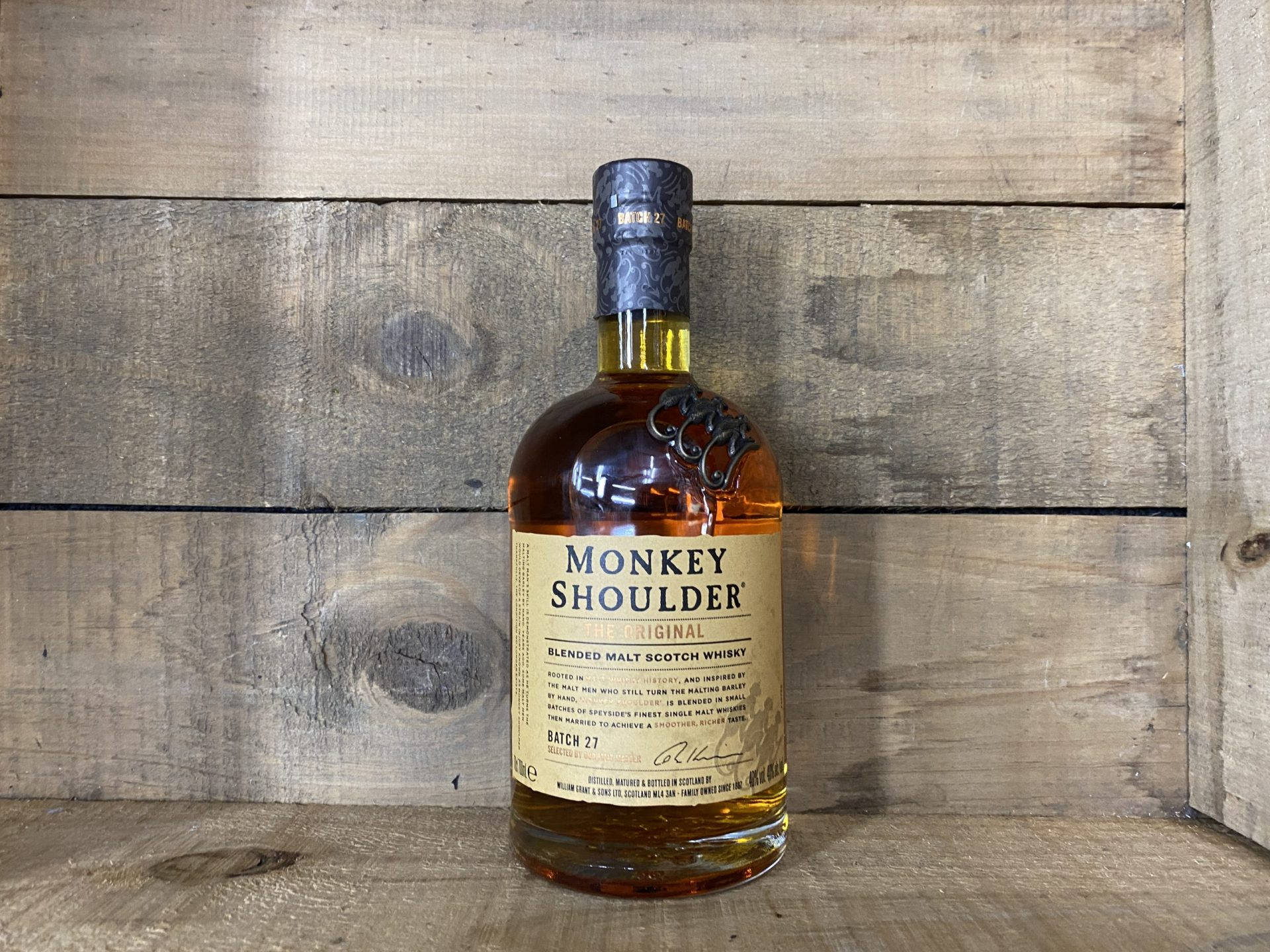 alcohol 桌布 壁紙 — 一瓶Monkey Shoulder威士忌放在質樸的木頭上，背景是風化的木牆。