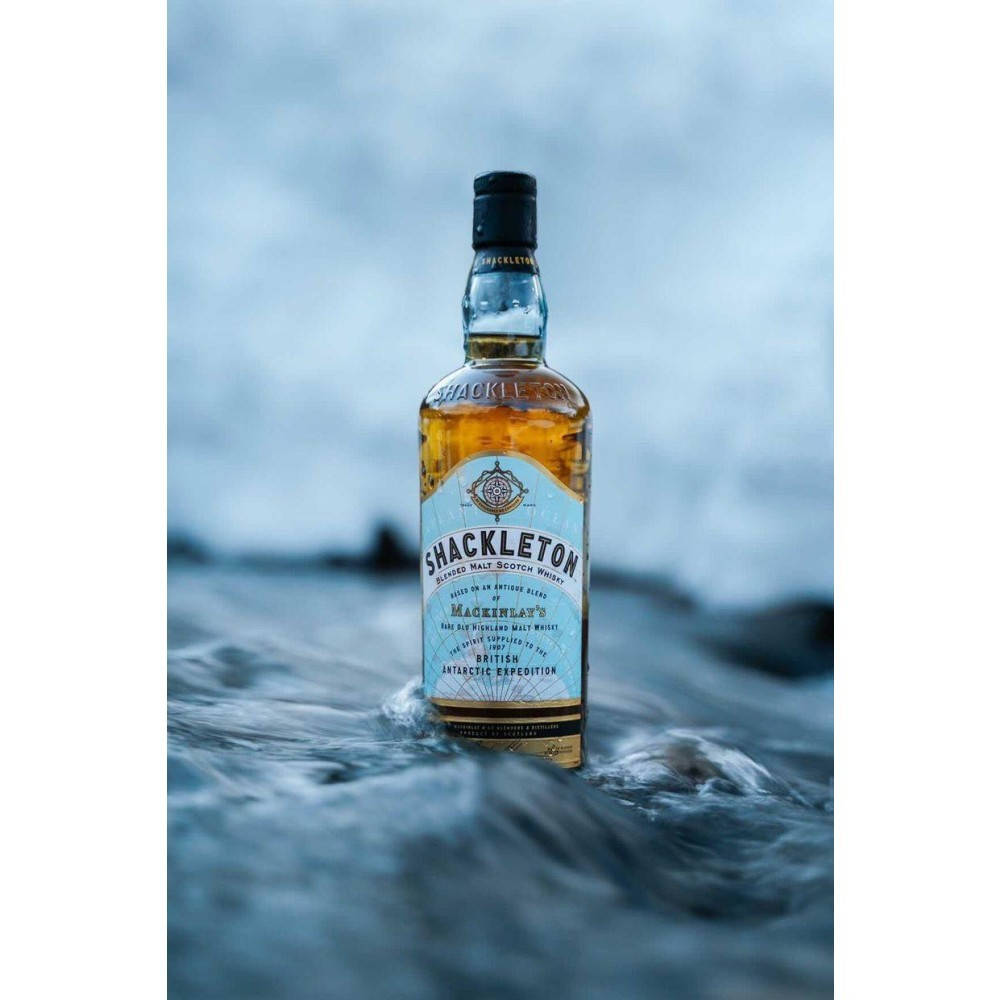飲料 桌布 壁紙 — 一瓶Shackleton威士忌在陰沉天空下直立於洶湧的海浪中。