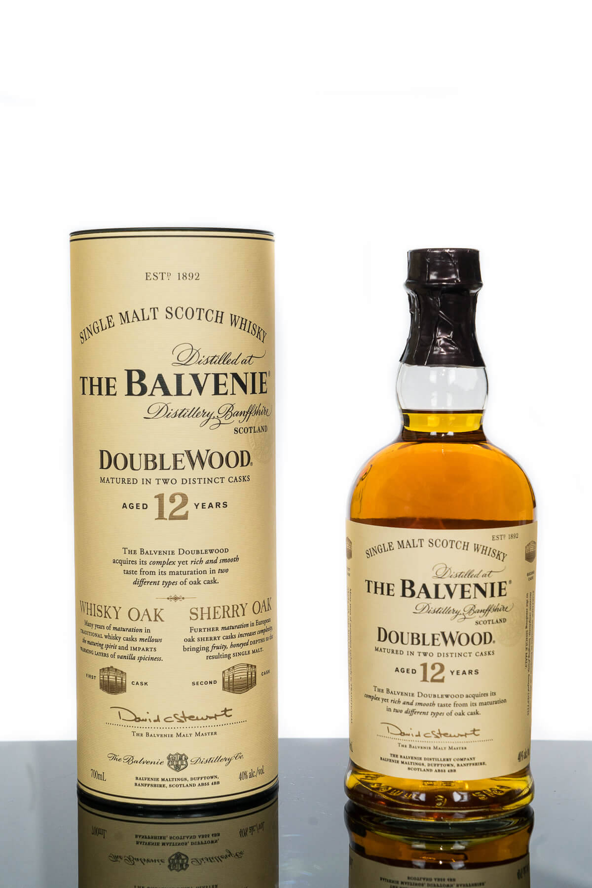 Drink 桌布 壁紙 — 一瓶The Balvenie 12 Year Old DoubleWood單一麥芽蘇格蘭威士忌，旁邊放著它的圓柱形盒子，置於反光表面上。