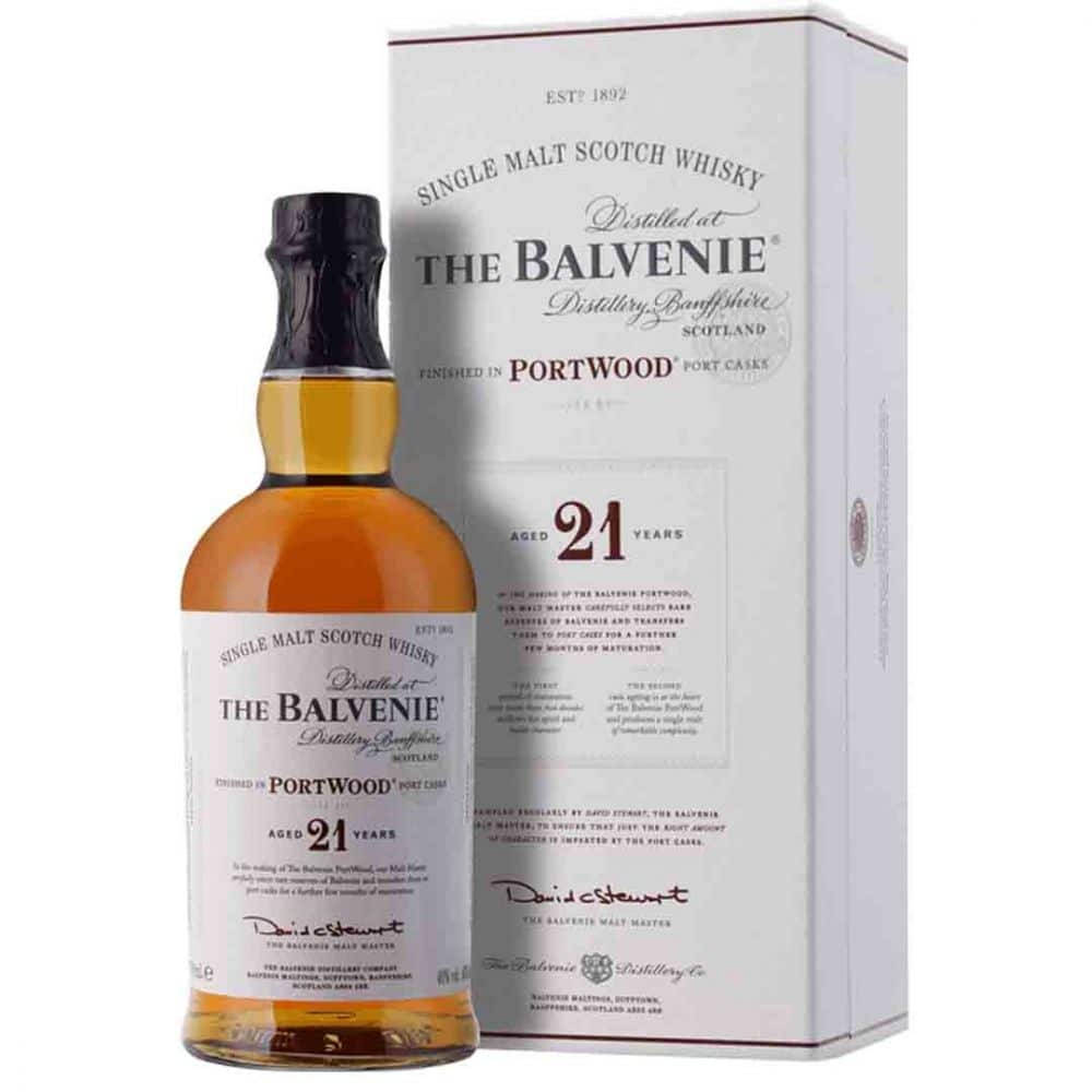 Drink 桌布 壁紙 — 一瓶The Balvenie 21年單一麥芽蘇格蘭威士忌，搭配其優雅的白色禮盒，兩者均展現豐富的琥珀色液體和精緻的字體設計。