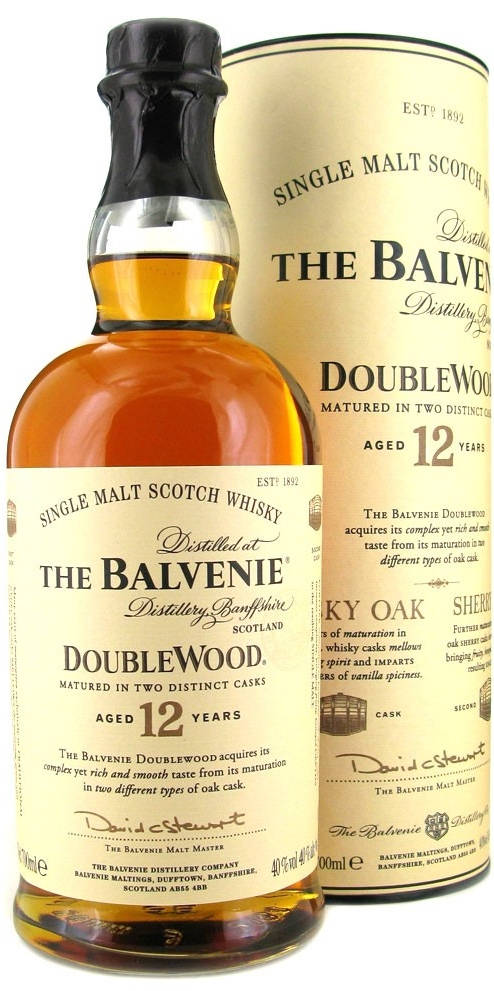 Drink 桌布 壁紙 — 一瓶The Balvenie DoubleWood 12 Year Old單一麥芽蘇格蘭威士忌放在其圓柱形盒子旁邊，展示琥珀色液體和優雅的字體設計。