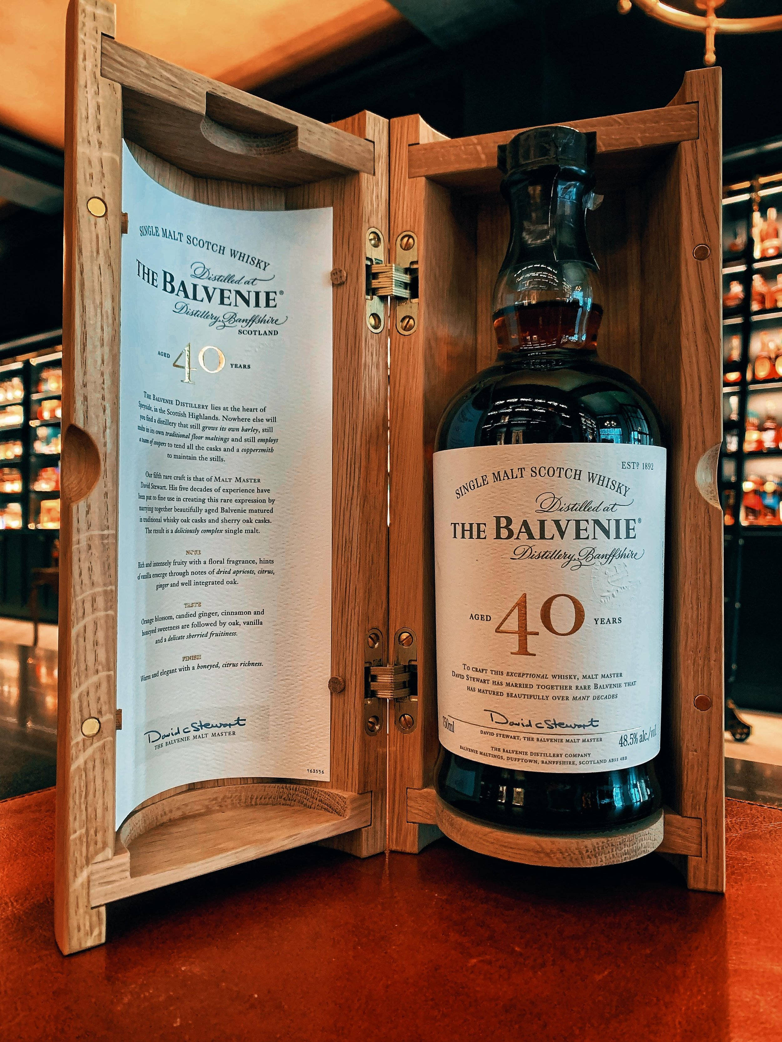 Drink 桌布 壁紙 — 一瓶奢華的40年The Balvenie單一麥芽威士忌，展示在其木製禮盒中，帶有詳細的標籤文字。
