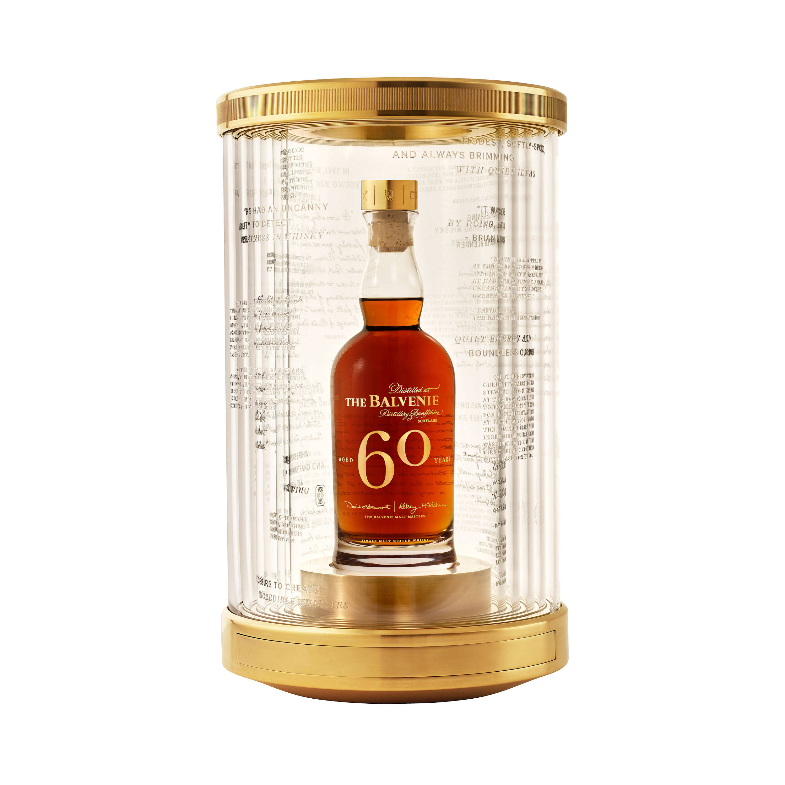 Drink 桌布 壁紙 — 一瓶奢華的60年The Balvenie威士忌，展示在帶有金色點綴的玻璃圓柱中，並刻有語錄。