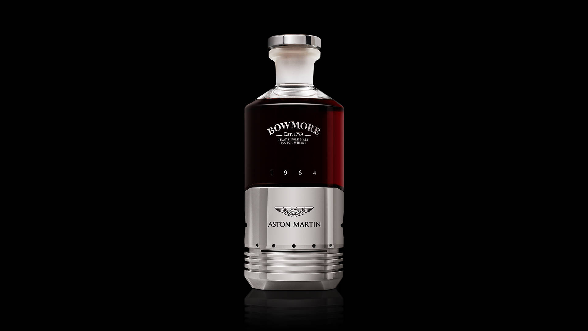 Whiskey 桌布 壁紙 — 一瓶帶有Aston Martin品牌標誌的時尚Bowmore 1964威士忌酒瓶，置於純黑色背景中央。
