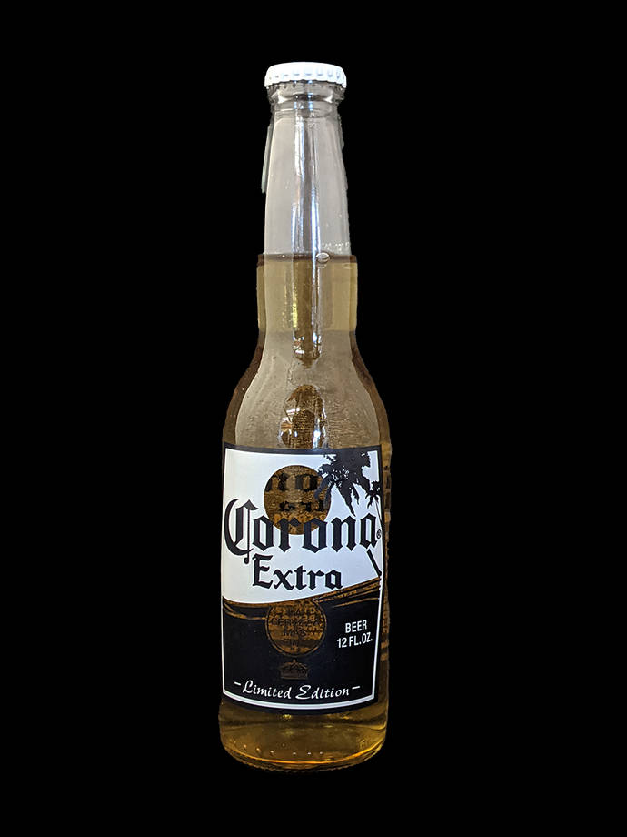 corona 桌布 壁紙 — 一瓶帶有限量版標籤的Corona Extra啤酒瓶，孤立地立在純黑色背景上。