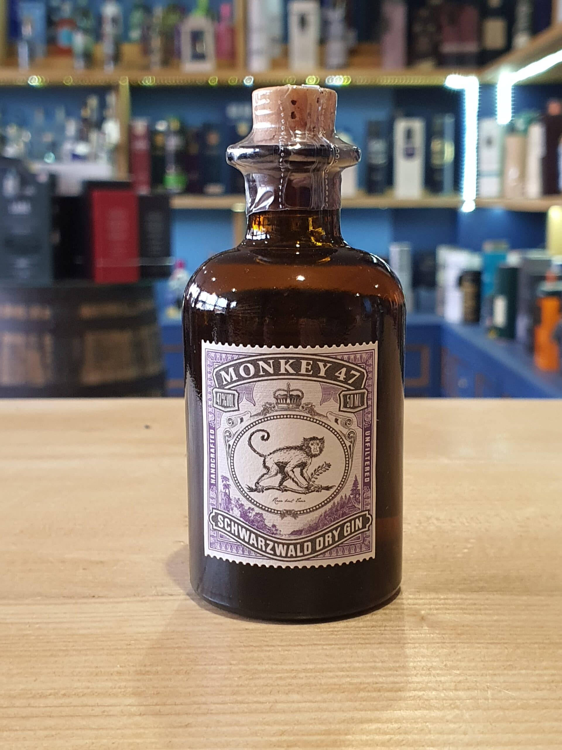 bottle 桌布 壁紙 — 一瓶復古琥珀色的Monkey 47 Schwarzwald Dry Gin放在木製吧檯上，背景是擺滿酒類的架子。