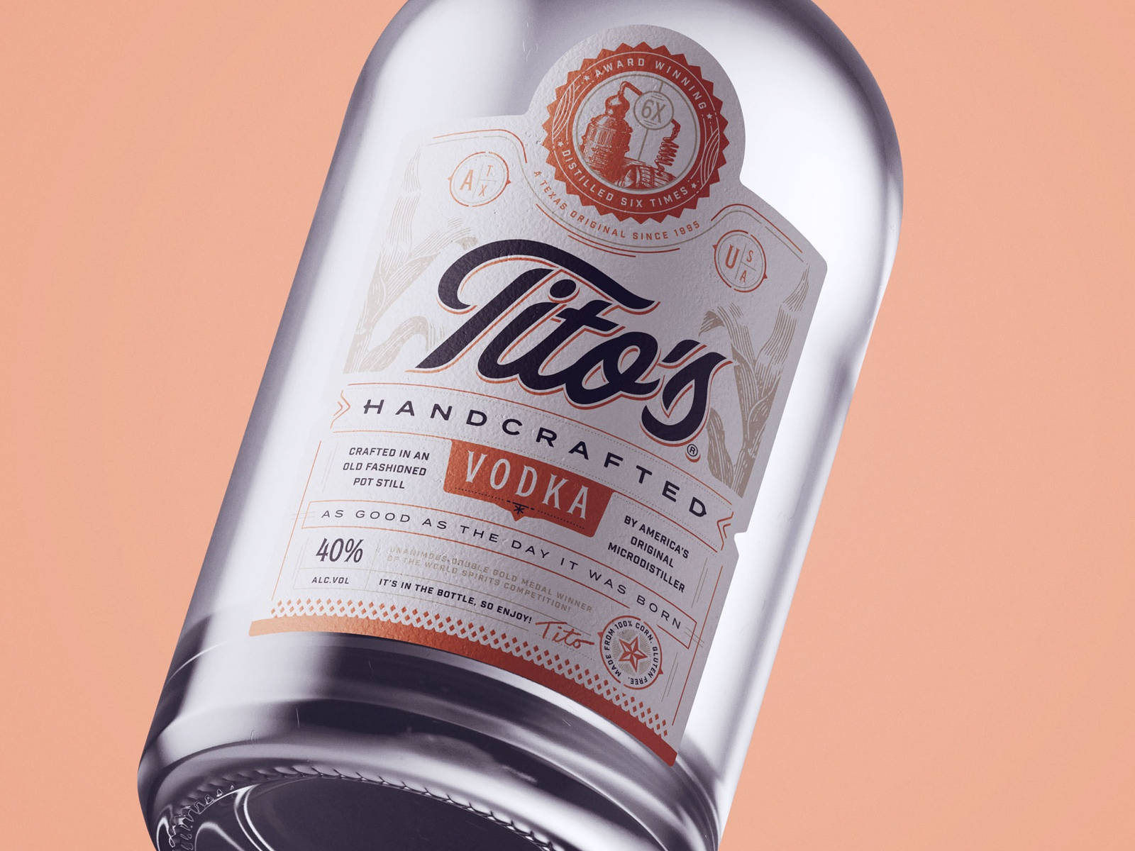 bottle 桌布 壁紙 — 一瓶流線型的Tito's Handcrafted Vodka酒瓶，傾斜置於柔和蜜桃色背景上，標籤細節清晰。