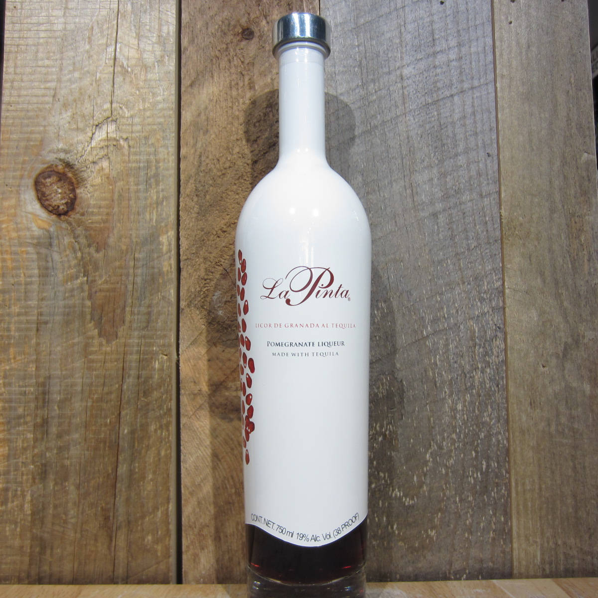 bottle 桌布 壁紙 — 一瓶白色La Pinla石榴利口酒，背景是帶有清晰木紋和節疤的質樸木板。