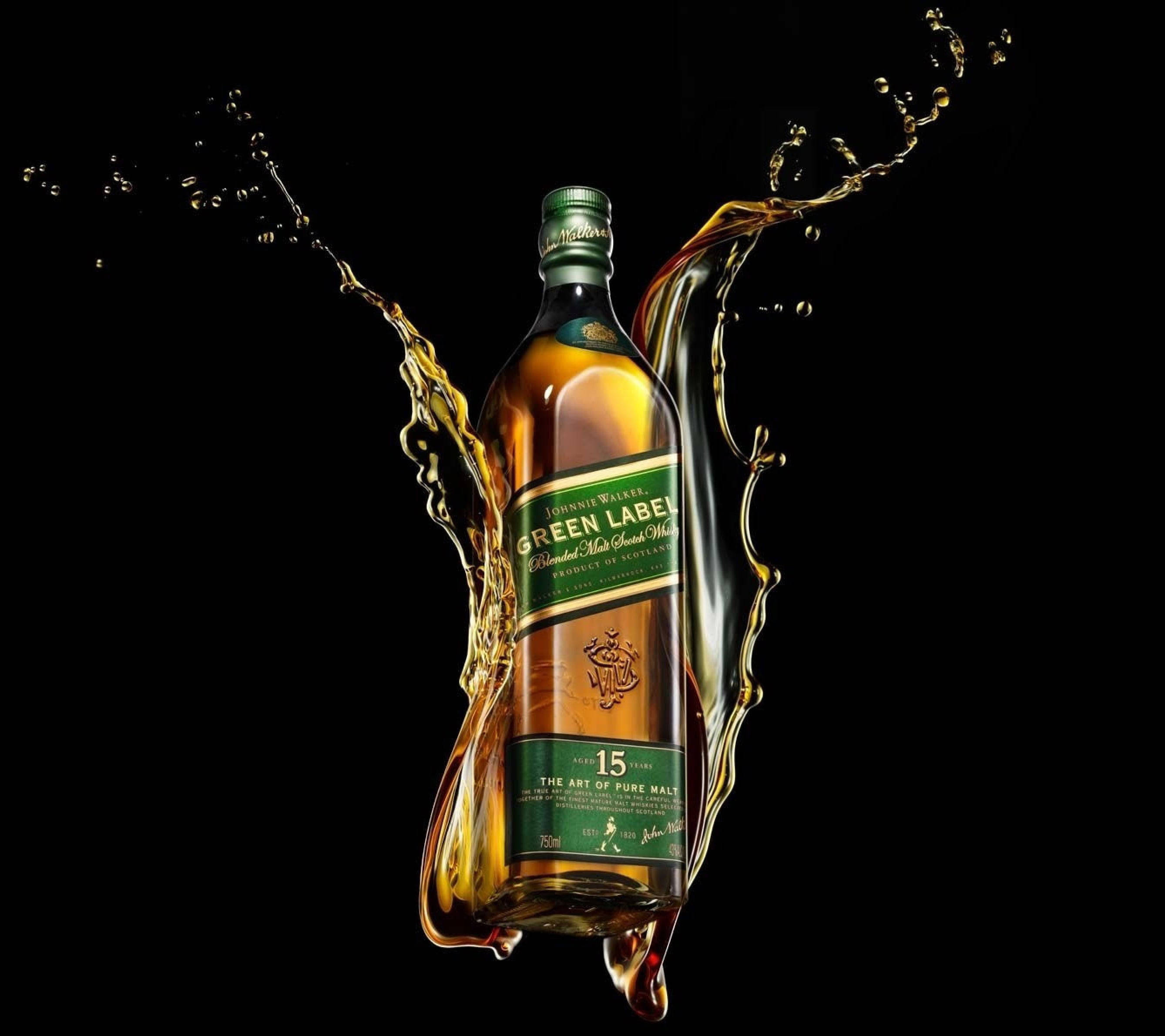 alcohol 桌布 壁紙 — 一瓶約翰走路綠牌威士忌，在純黑背景上被動態的金色液體飛濺所環繞。