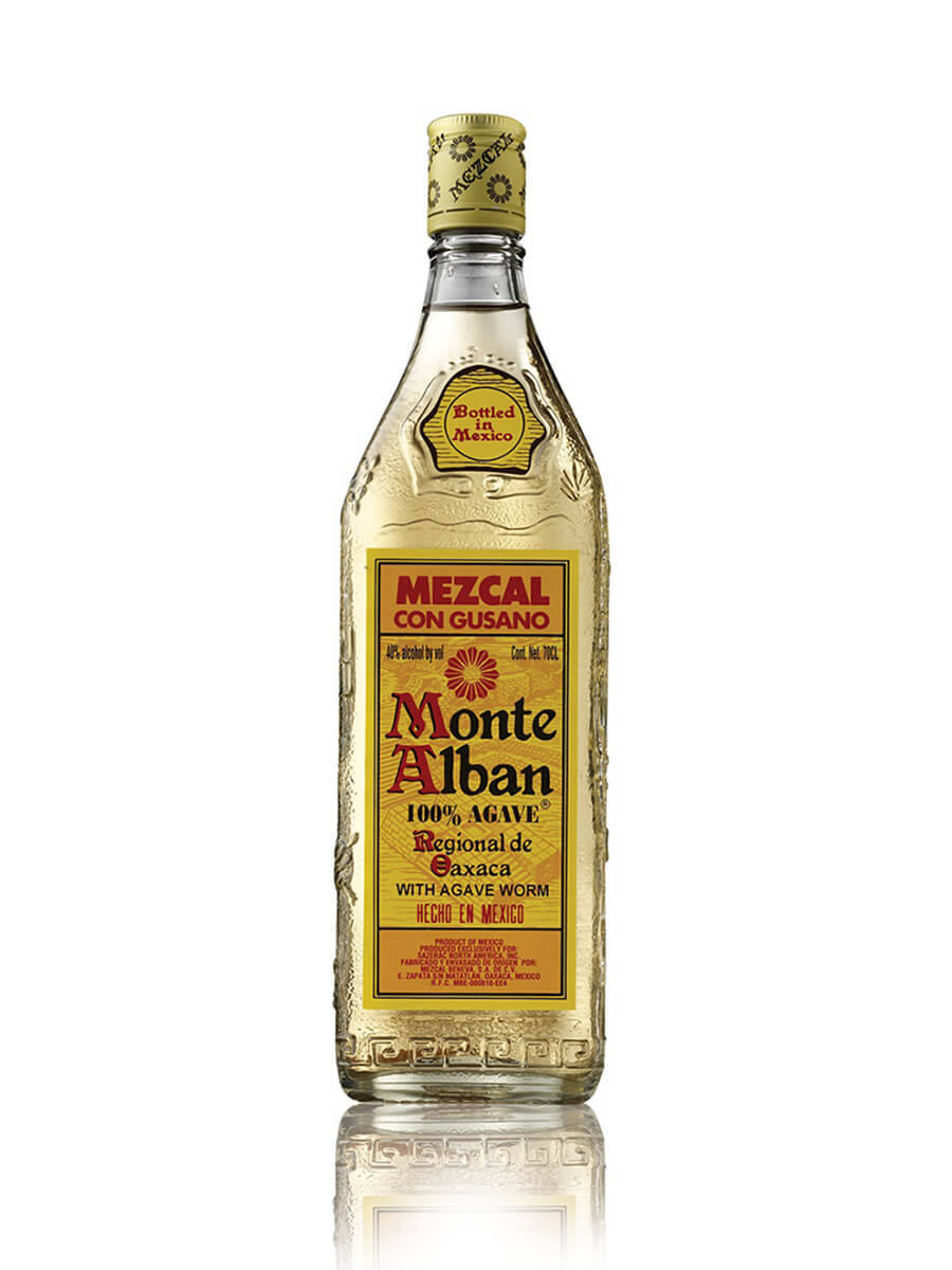 Drink 桌布 壁紙 — 一瓶透明的 Monte Alban Mezcal con Gusano，帶有龍舌蘭蟲標籤，孤立地立在反光的白色表面上。