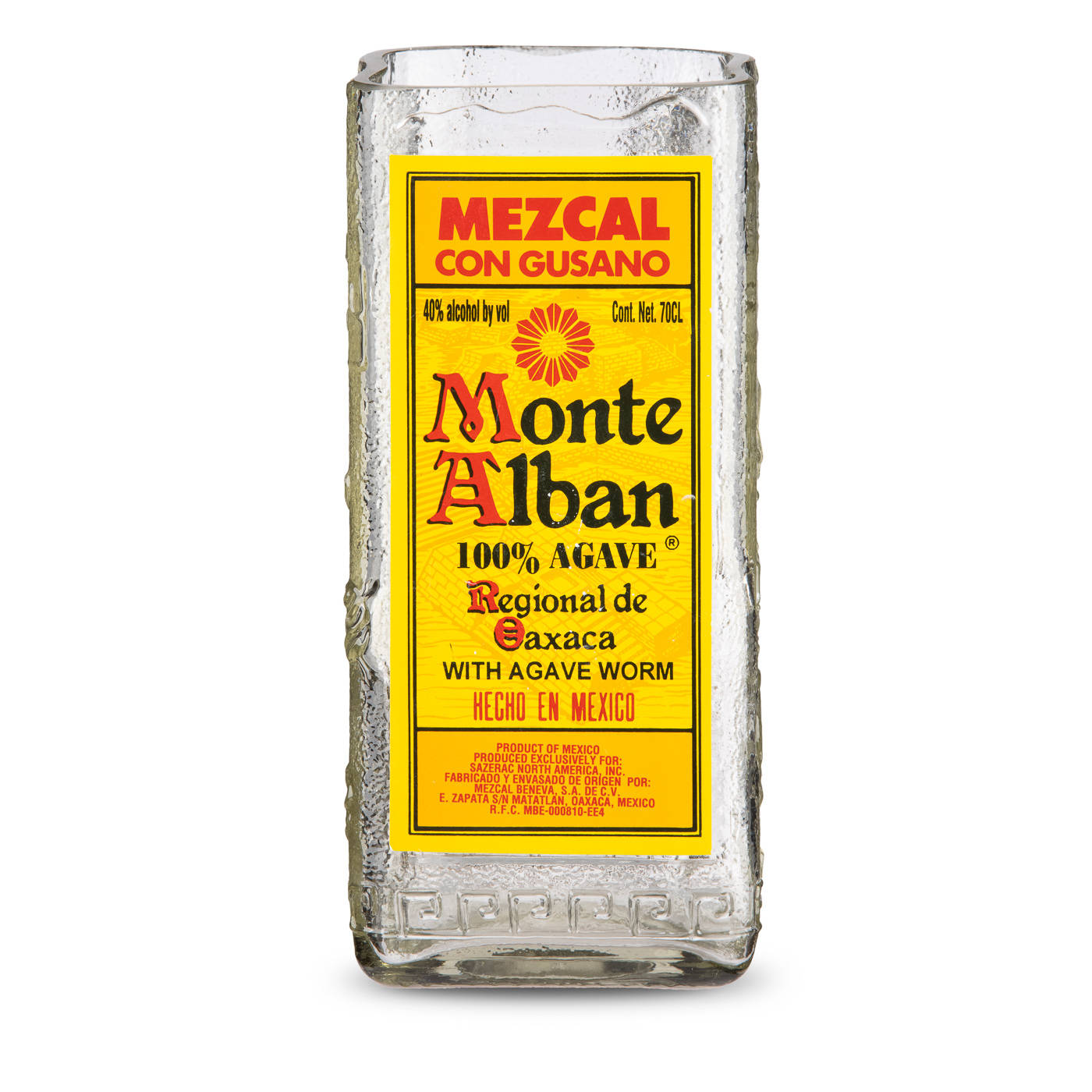 Drink 桌布 壁紙 — 一瓶透明的 Monte Alban Mezcal con Gusano 玻璃瓶，帶有亮黃色標籤和紅色文字，置於白色背景前。