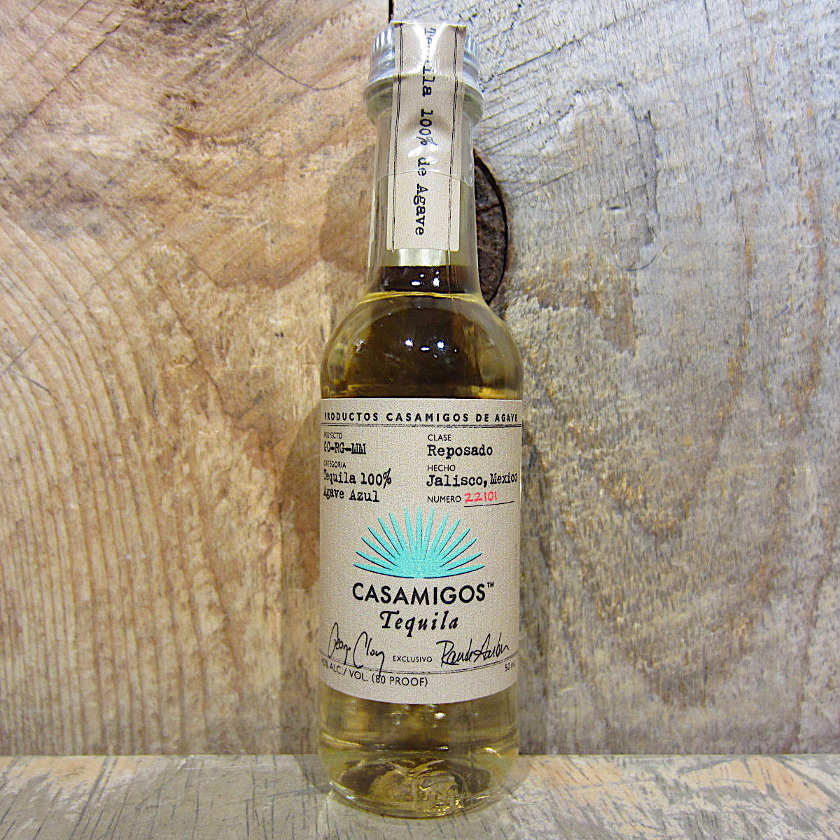 bottle 桌布 壁紙 — 一瓶透明的Casamigos Reposado龍舌蘭酒，帶有綠松石色太陽爆發標籤，放在質樸的木頭上，背景是風化的木質背景。