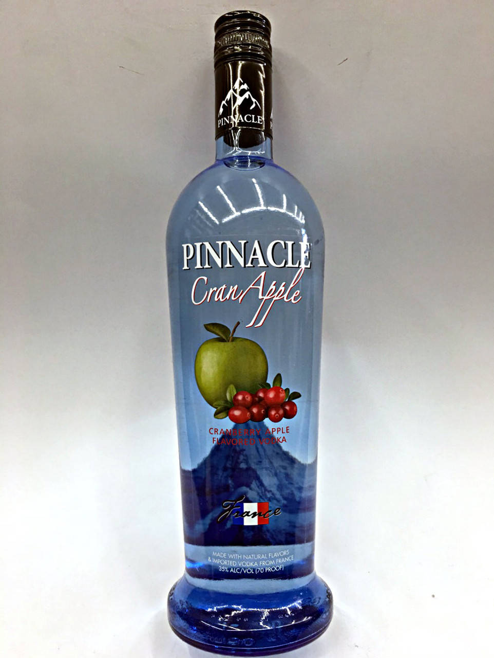 bottle 桌布 壁紙 — 一瓶高大的藍色Pinnacle CranApple風味伏特加，立在純白背景上，標籤清晰，帶有水果圖案。