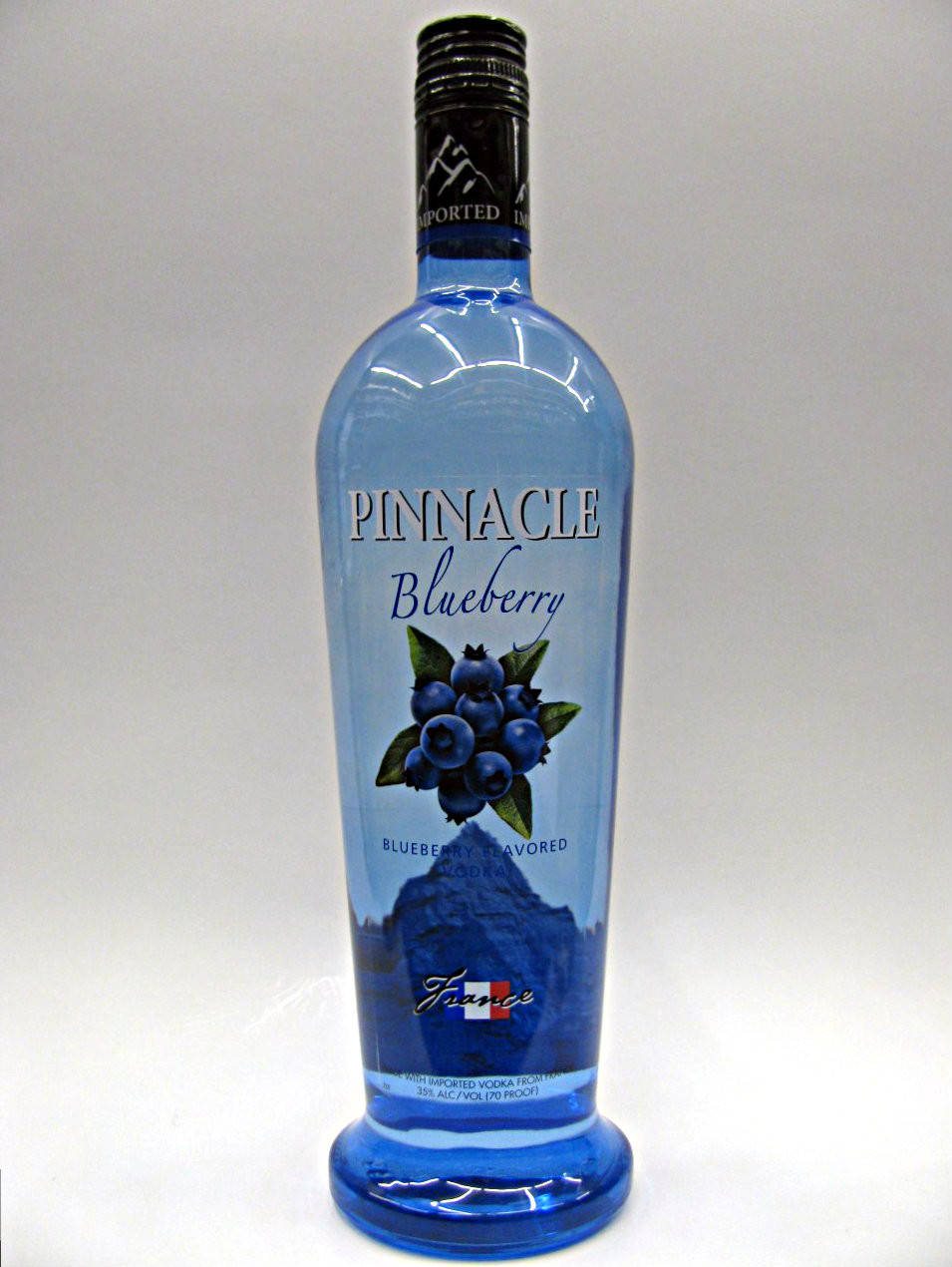 bottle 桌布 壁紙 — 一瓶高大的藍色玻璃瓶Pinnacle Blueberry伏特加，立在純白背景前，帶有黑色瓶蓋和藍莓插圖。