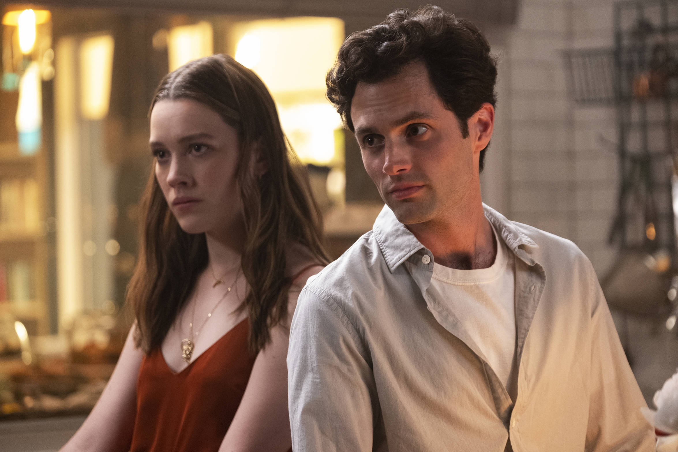 Netflix 桌布 壁紙 — 一男一女並排坐在燈光溫暖的廚房裡，表情緊張，背景有柔和的散景燈光。