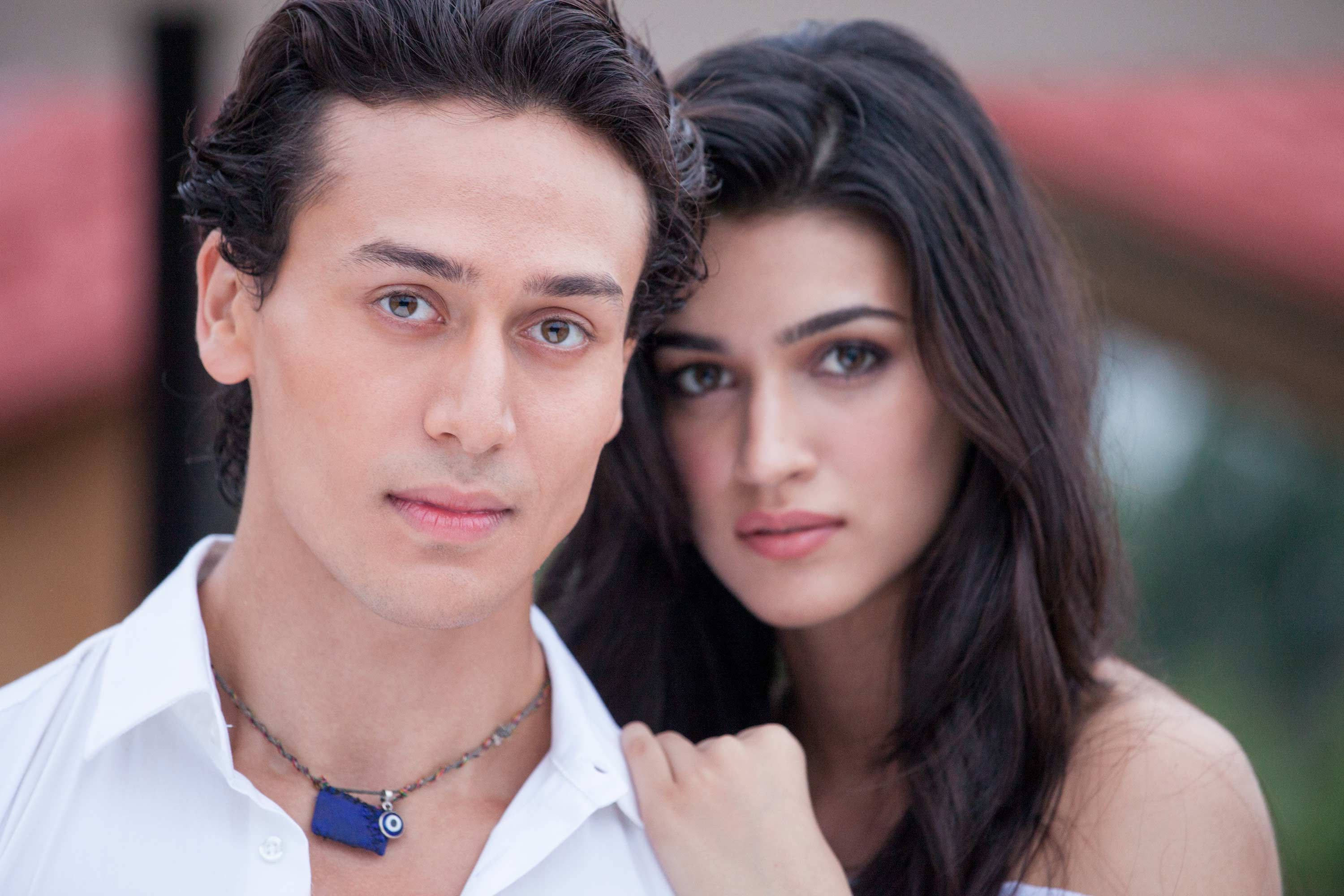 Kriti 桌布 壁紙 — 一男一女以強烈的眼神近距離擺姿勢，背景是柔和模糊的戶外景色。