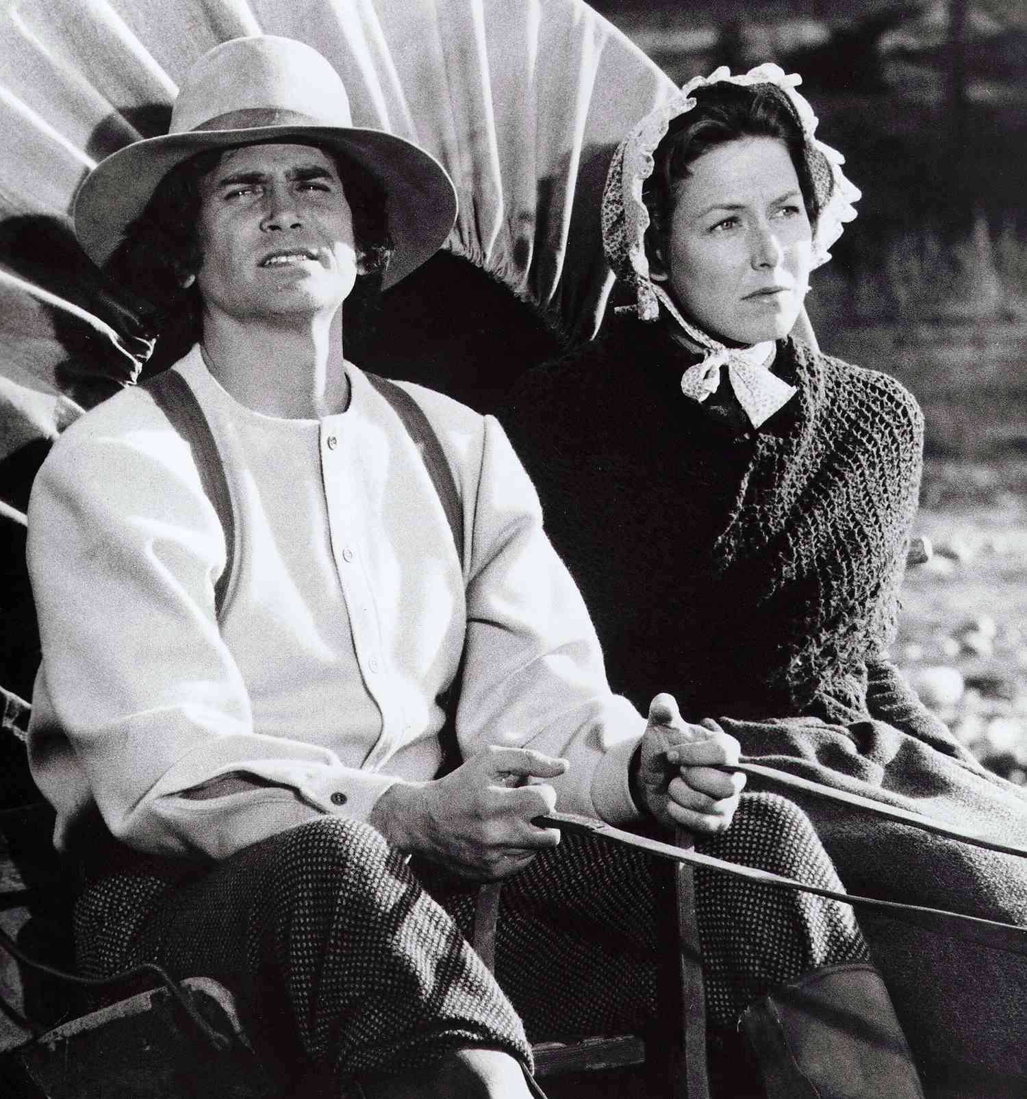 Michael Landon 桌布 壁紙 — 一男一女穿著時代服裝並排坐在有篷馬車上，神情嚴肅地向前看。
