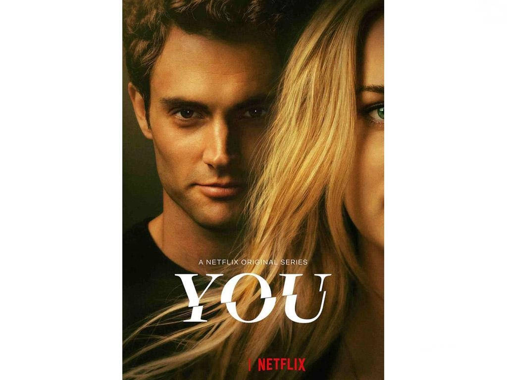Netflix 桌布 壁紙 — 一男一女近距離接觸，在溫暖燈光下眼神交織，帶有標題「YOU」和Netflix品牌標誌。