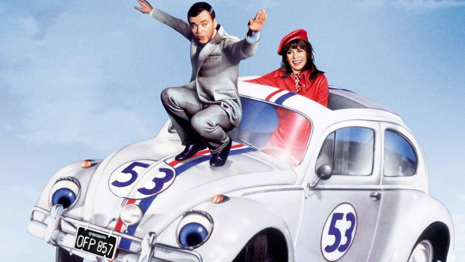 Herbie 桌布 壁紙 — 一男一女開心地在銀色賽車上擺姿勢，賽車有卡通眼睛和53號，背景是晴朗的藍天。