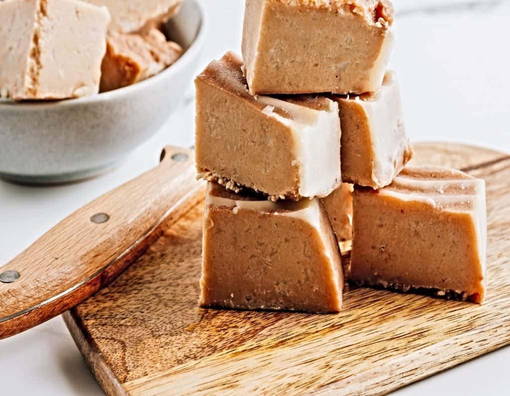 Penuche Fudge 桌布 壁紙 — 一疊奶油花生醬軟糖方塊放在木砧板上，旁邊有刀和碗。