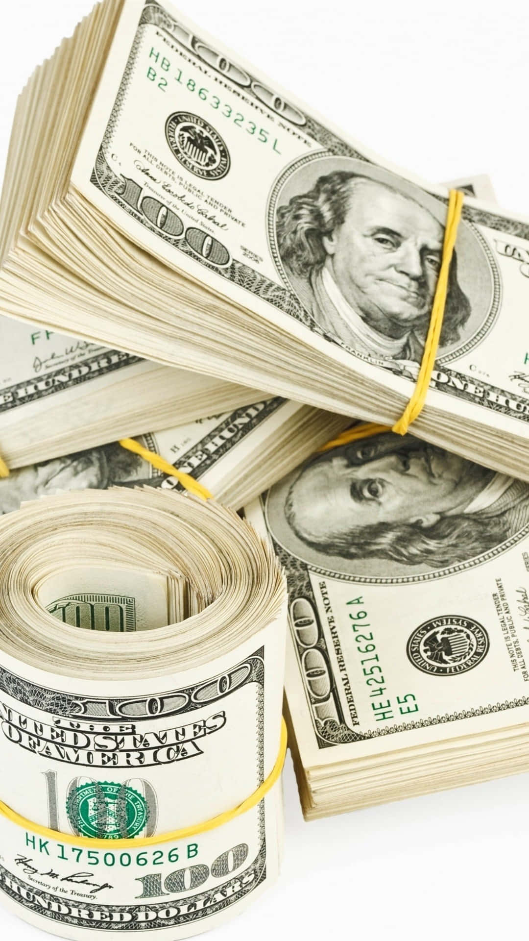 金錢 桌布 壁紙 — 一疊疊和一卷嶄新的百元美鈔，用黃色綑帶綁著，放在純白背景前。