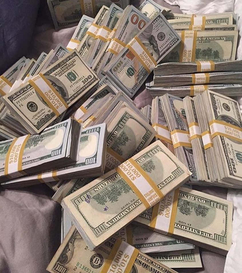 Rich 桌布 壁紙 — 一疊疊捆綁好的百元美鈔散落在柔軟的紫色布料表面上，混亂地展示財富。