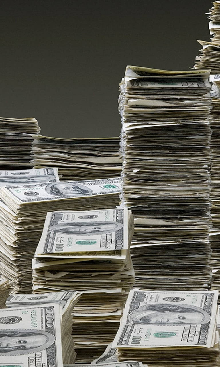 money iPhone 桌布 壁紙 — 一疊疊清脆的百元美鈔聳立在深灰色背景上，營造出累積財富的強大視覺效果。