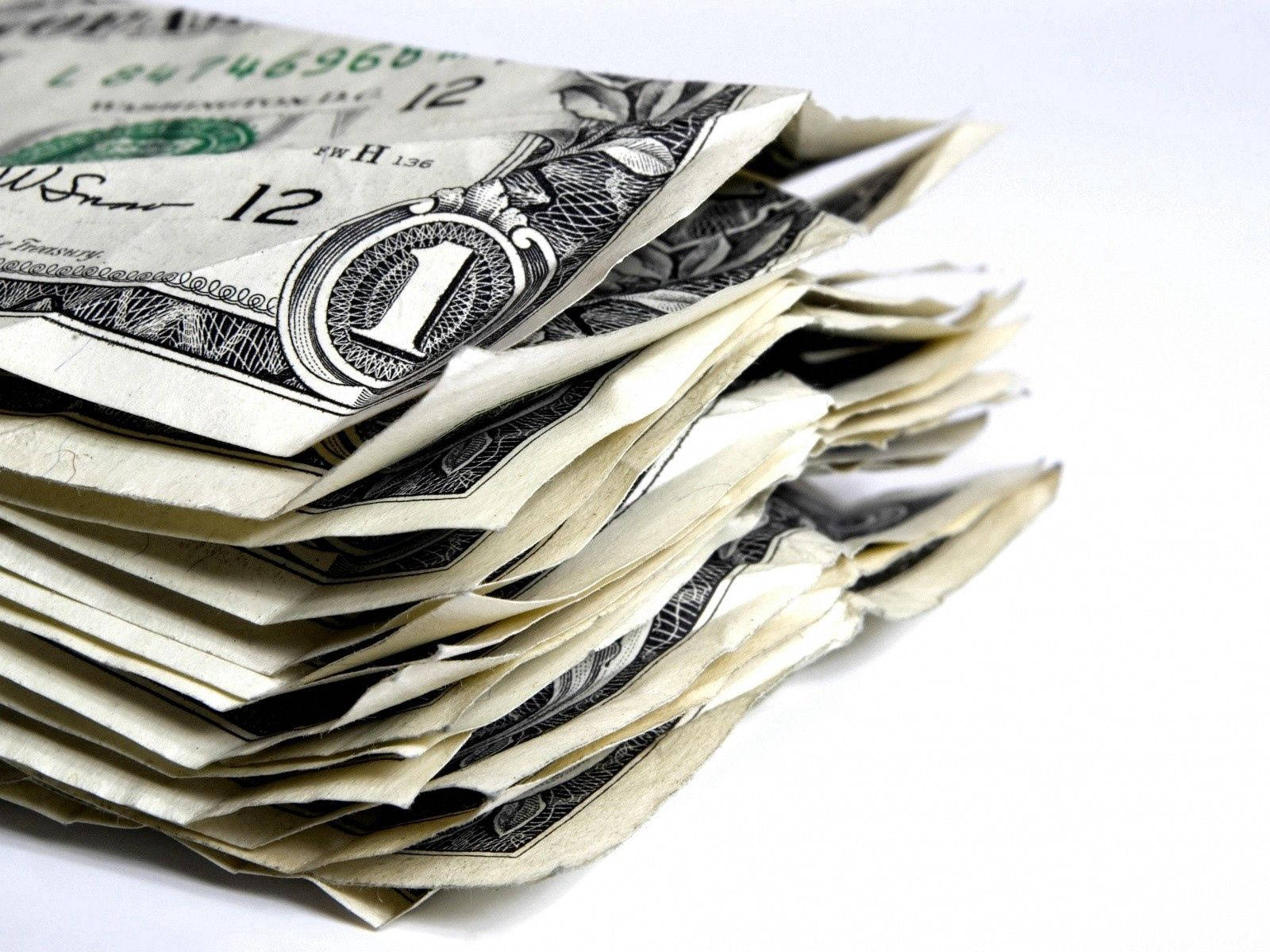 No Money 桌布 壁紙 — 一疊皺巴巴的一美元紙鈔雜亂地堆放在純白色背景上的特寫。