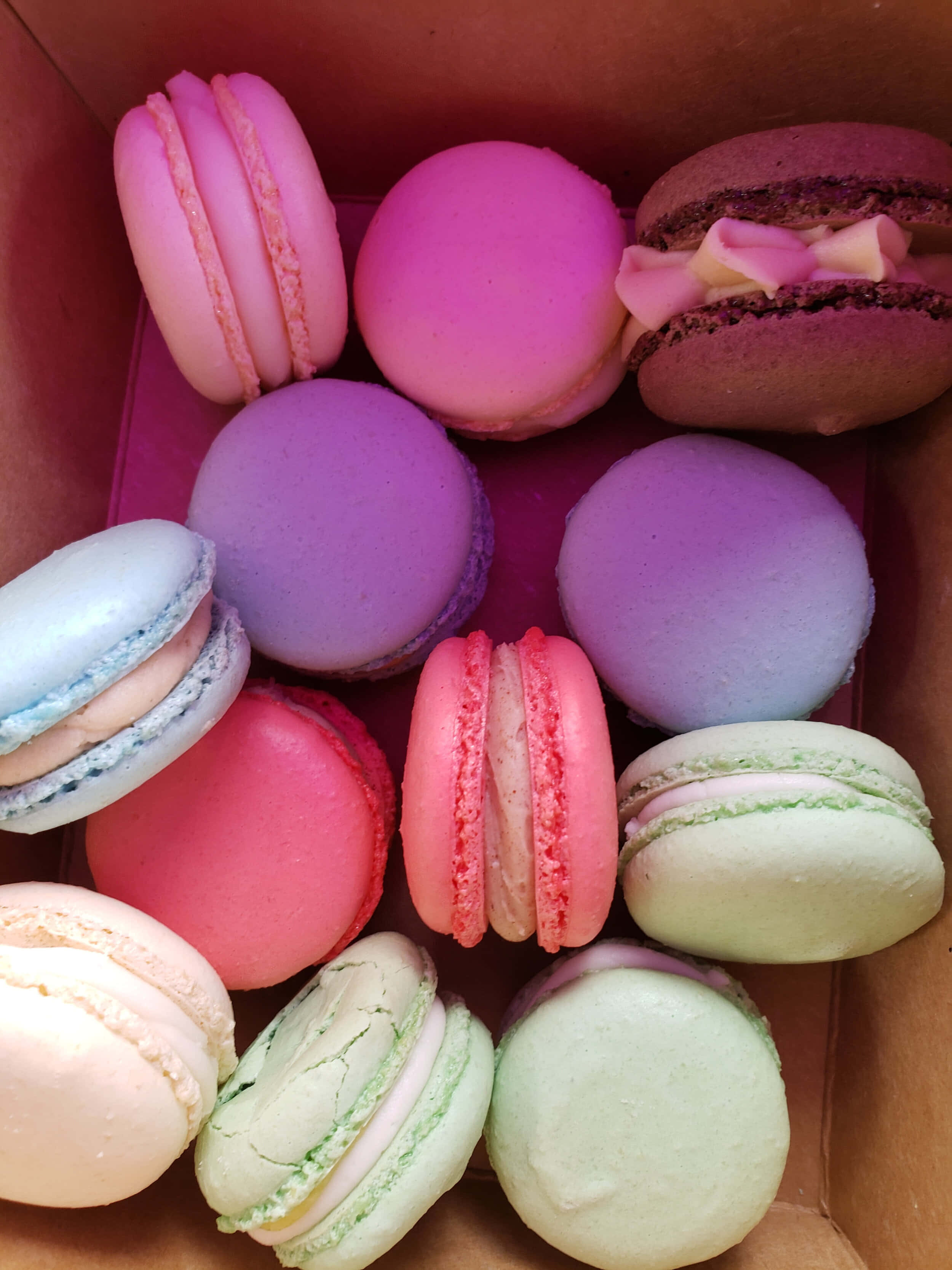 yummy 桌布 壁紙 — 一盒色彩繽紛的粉彩色馬卡龍，有粉紅、紫、藍、綠和蜜桃色，配上奶油餡料。