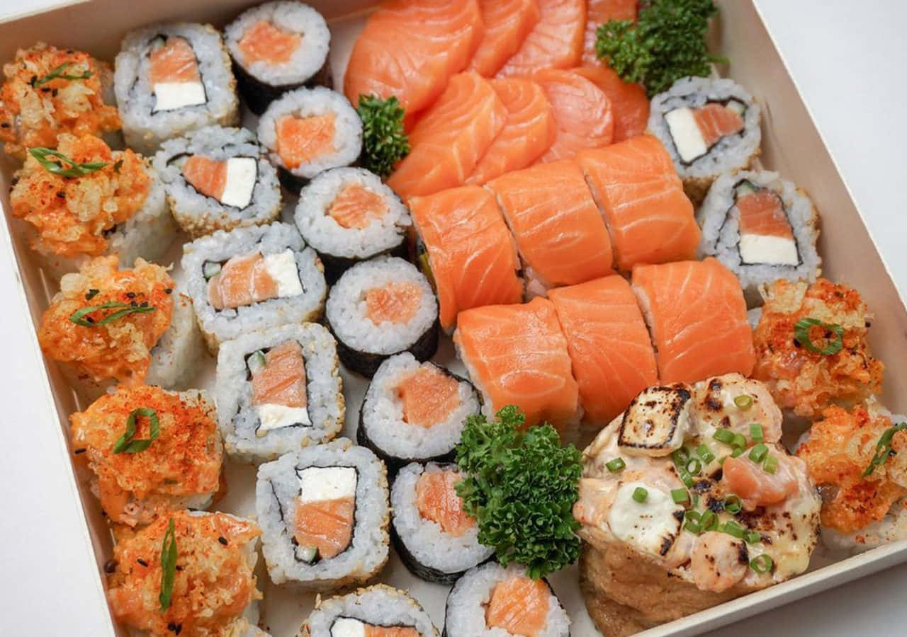 Salmon 桌布 壁紙 — 一盒色彩繽紛的綜合壽司，包含鮭魚生魚片卷、天婦羅卷和燒烤卷，並以歐芹裝飾。