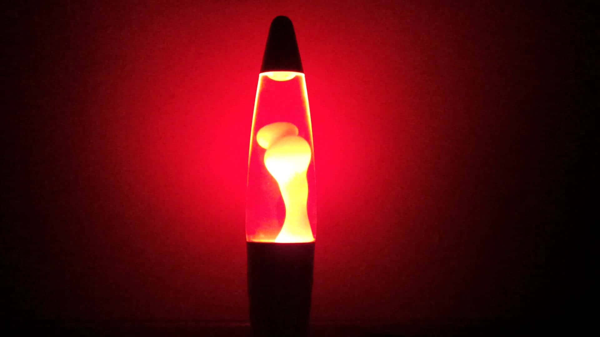 lava lamp 桌布 壁紙 — 一盞發光的熔岩燈在昏暗的房間裡，以深紅色背景襯托著溫暖的琥珀色蠟，脈動著光芒。