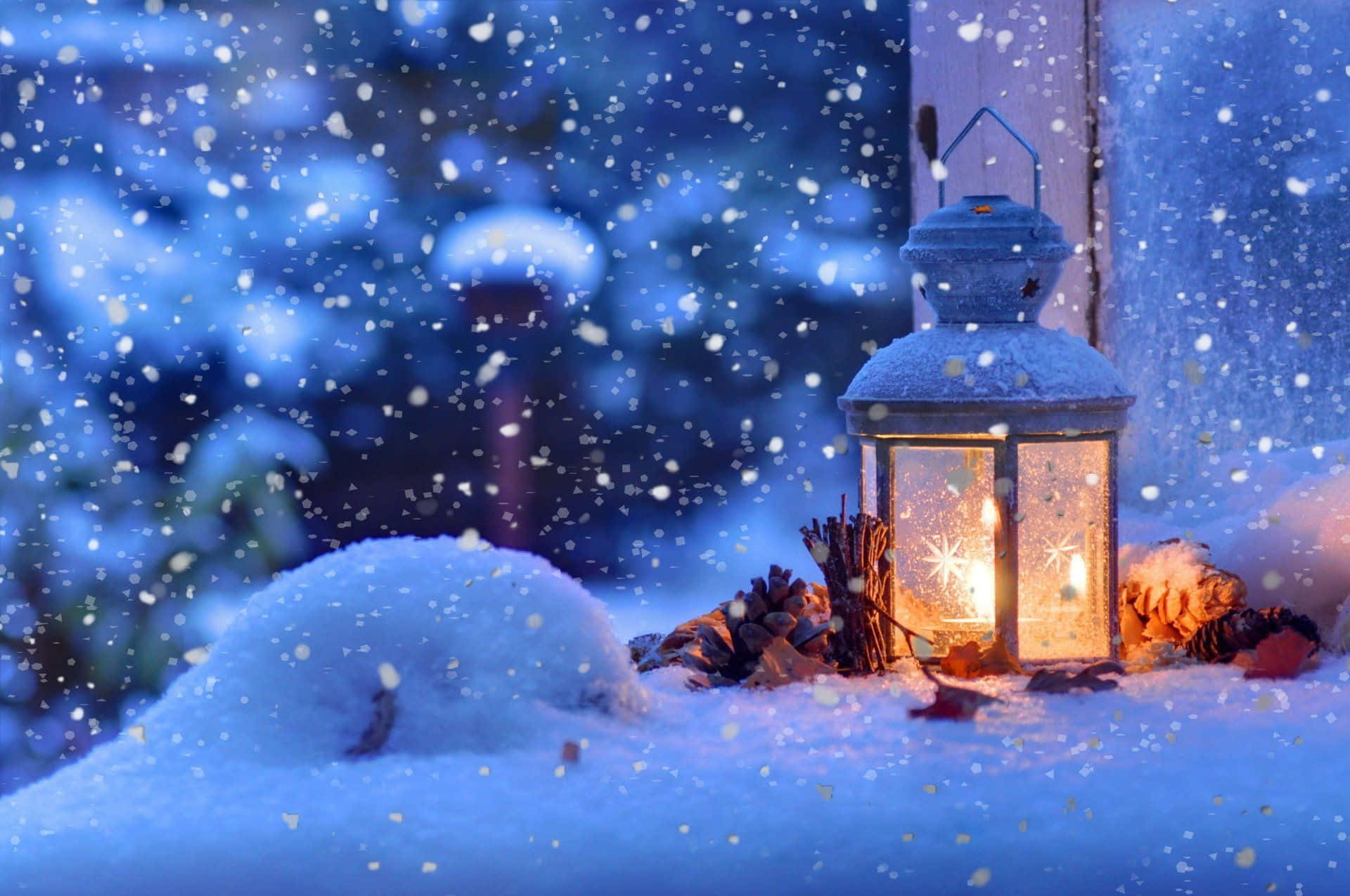 冬季聖誕 桌布 壁紙 — 一盞發光的燈籠在雪地上投射出溫暖的光芒，雪花在模糊的冬夜背景下飄落。