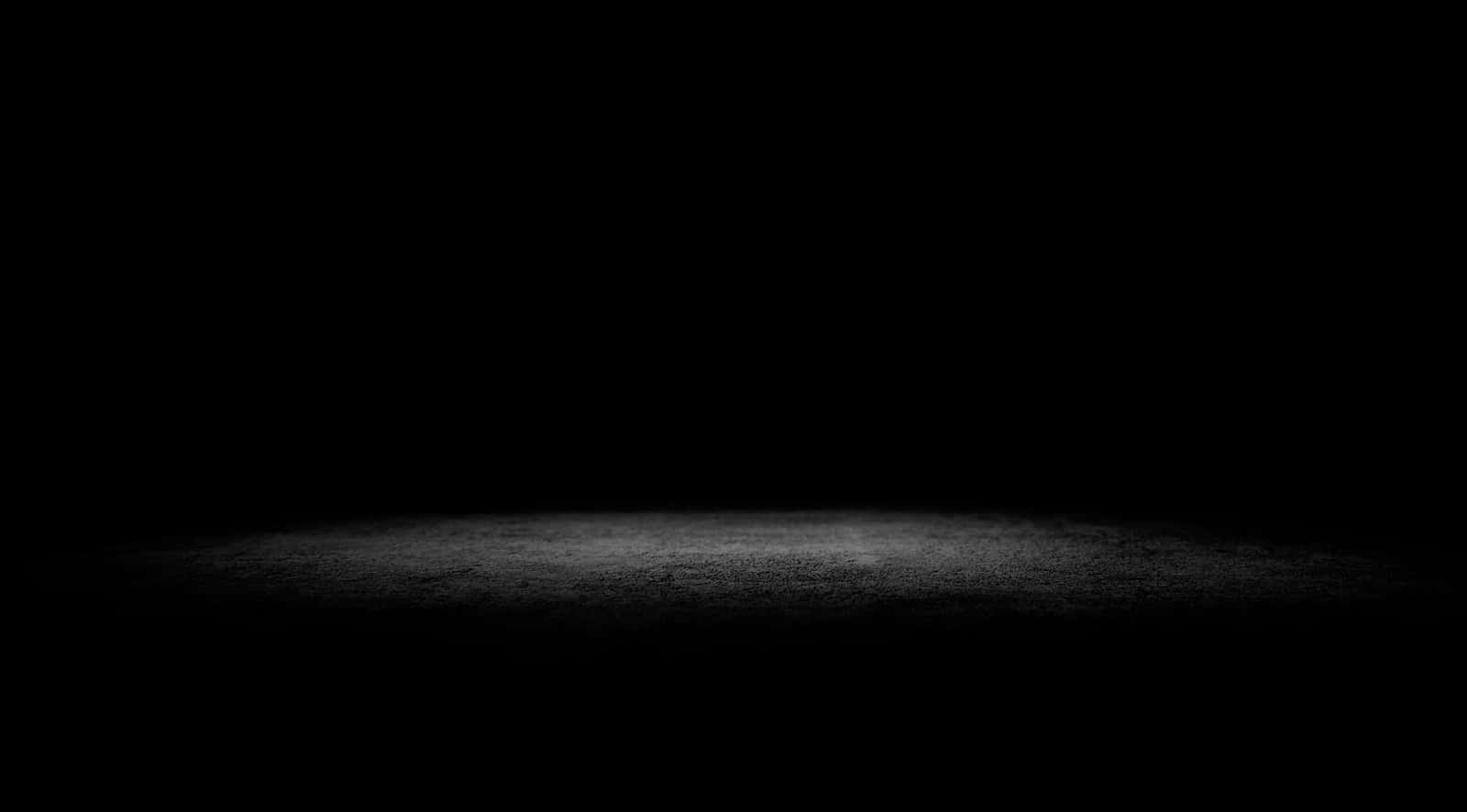 Dark Corner 桌布 壁紙 — 一盞聚光燈照亮了漆黑虛空中的紋理地板，營造出戲劇性的對比。