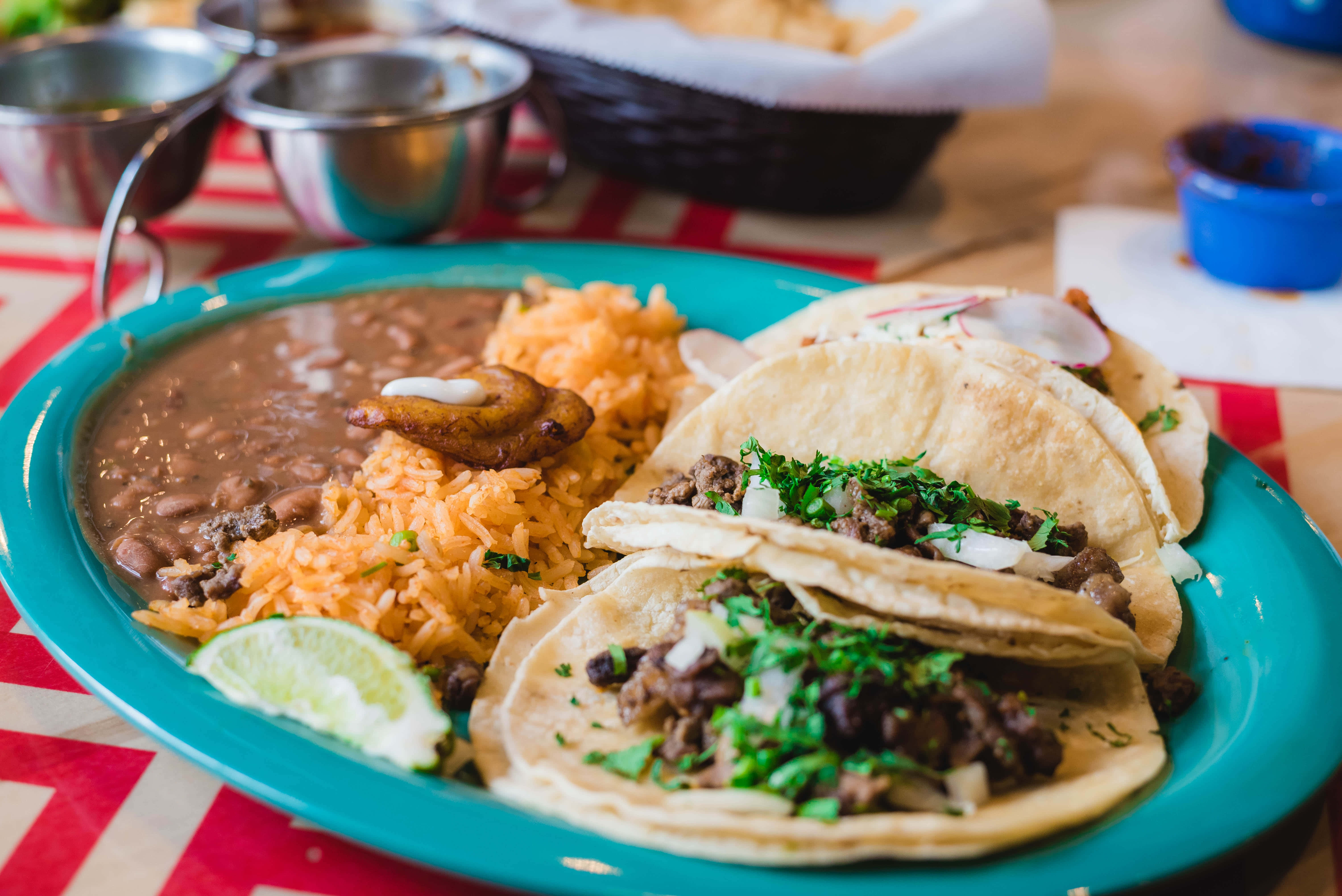 Mexican 桌布 壁紙 — 一盤充滿活力的墨西哥玉米餅，配上豆子、米飯和萊姆，放在紅白格子桌布上。