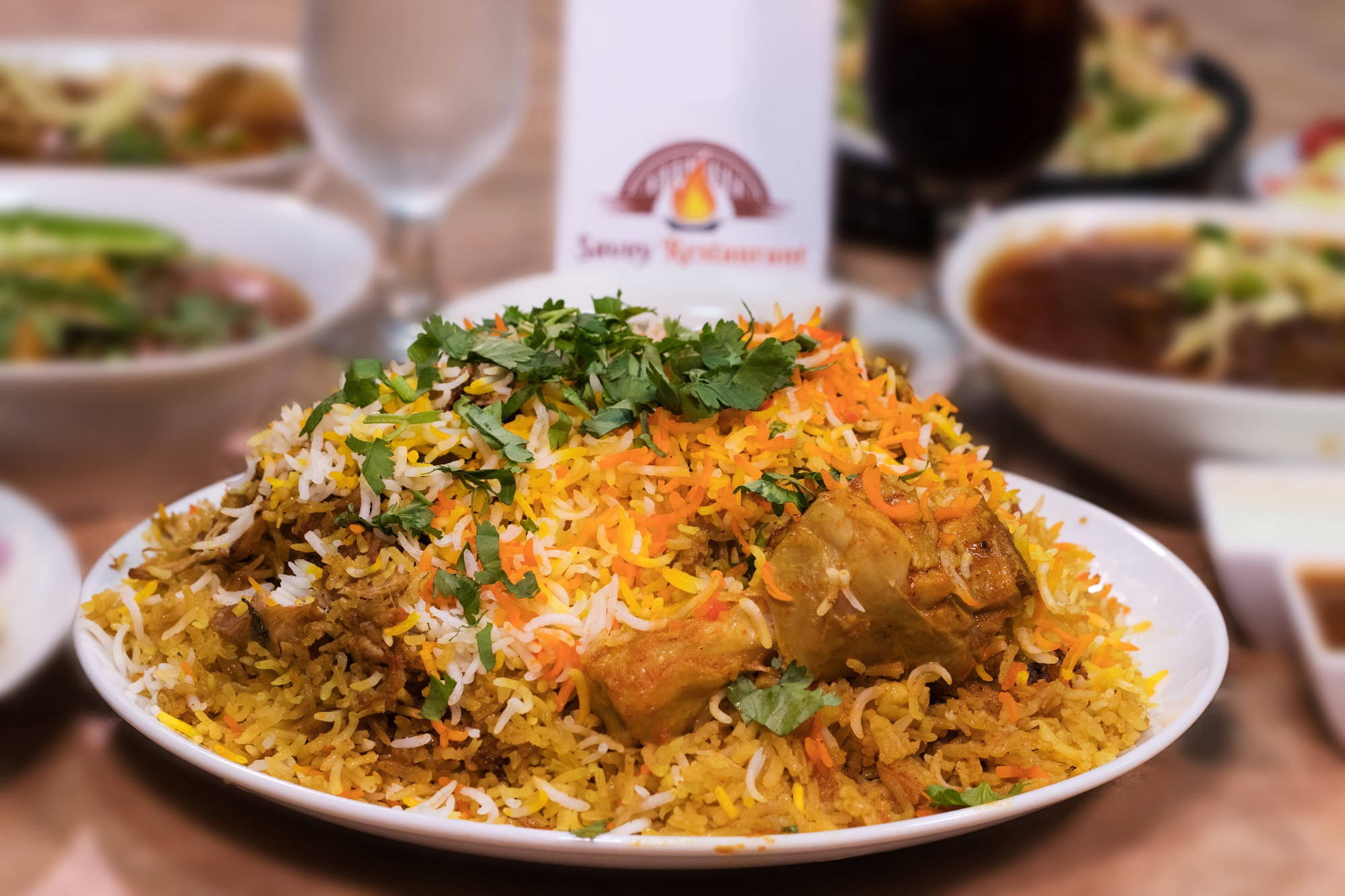 Karachi 桌布 壁紙 — 一盤冒著熱氣的鮮黃色米飯，搭配胡蘿蔔和香菜，上面放著一塊多汁的雞肉。