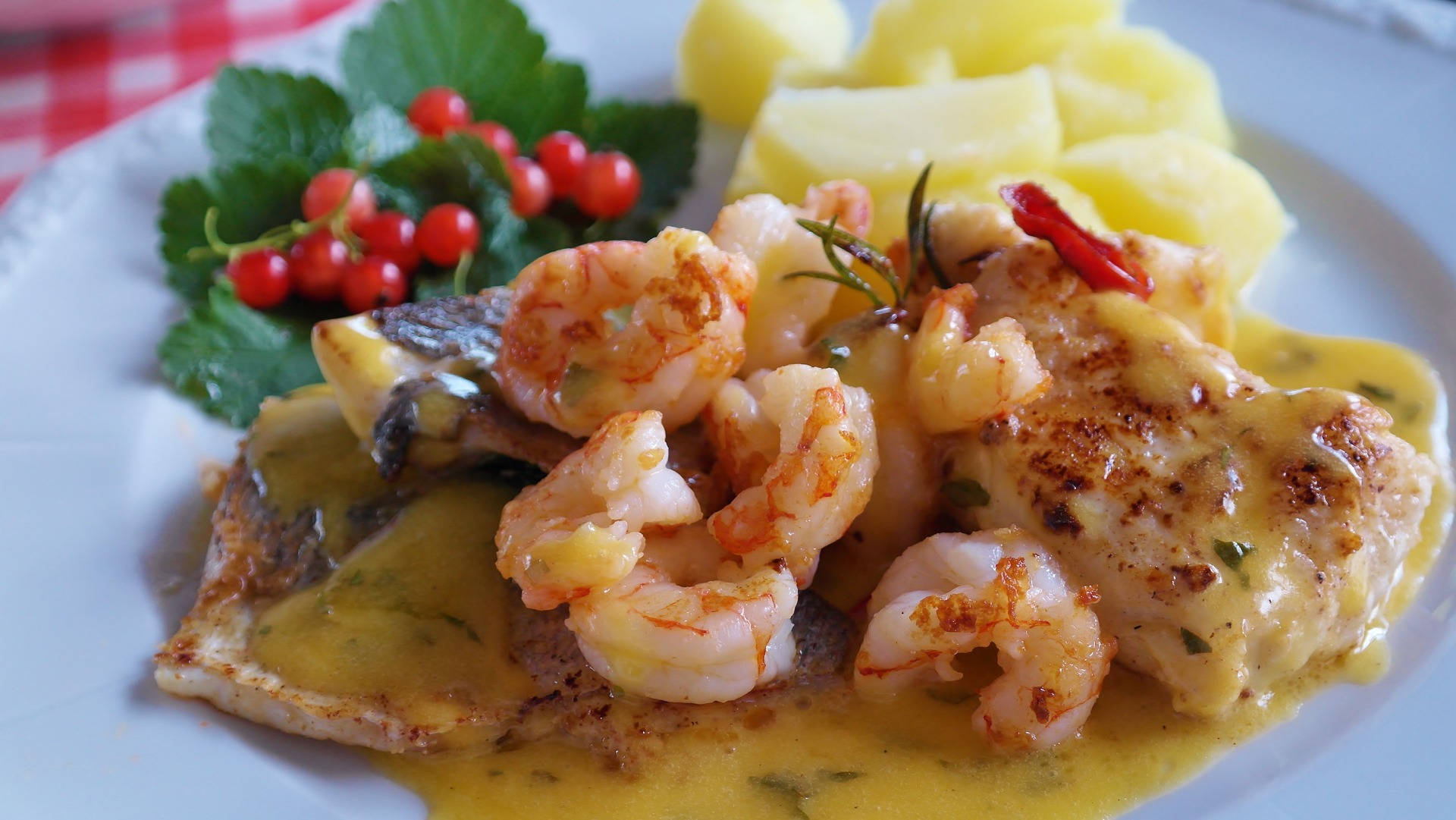 Prawns 桌布 壁紙 — 一盤多汁的蝦和魚柳搭配奶油醬汁，並以紅醋栗和香草點綴。