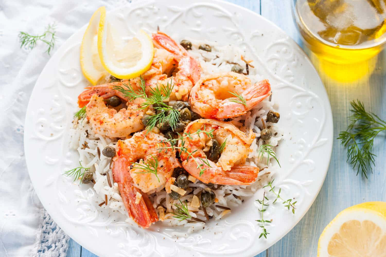 shrimp 桌布 壁紙 — 一盤多汁蝦仁配飯，飾以酸豆、蒔蘿和檸檬角，旁邊放著一杯啤酒。