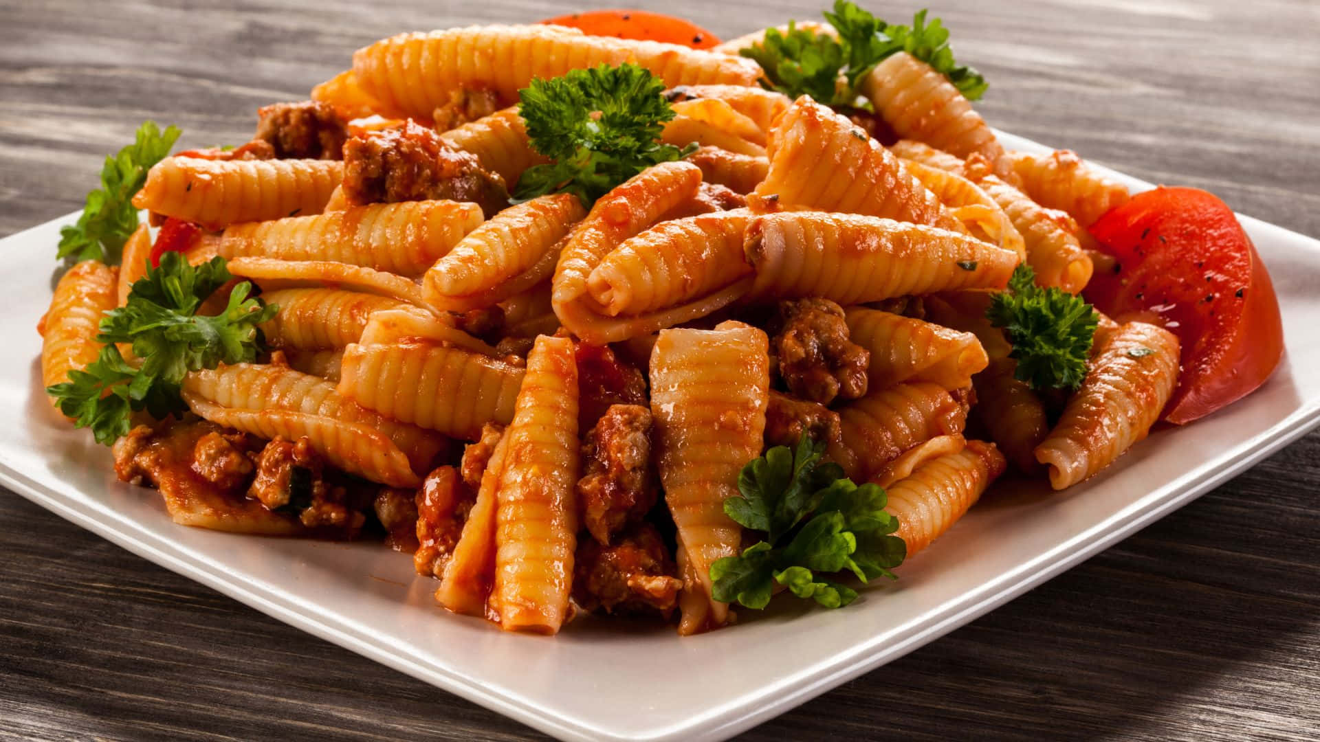 Best Pasta 桌布 壁紙 — 一盤奶油義大利麵搭配肉醬和新鮮歐芹裝飾，放在木桌上。
