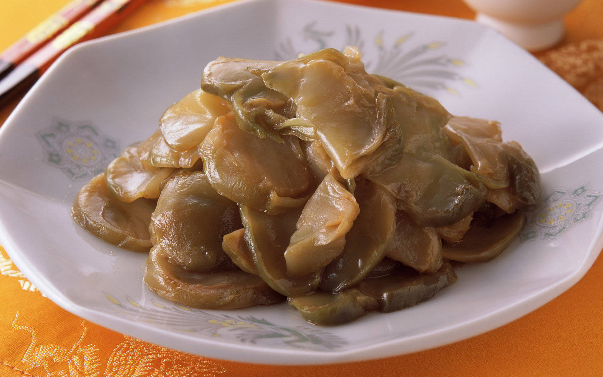 4K 食物 桌布 壁紙 — 一盤油亮亮的燉醃蘑菇放在橙色桌布上，旁邊有筷子。
