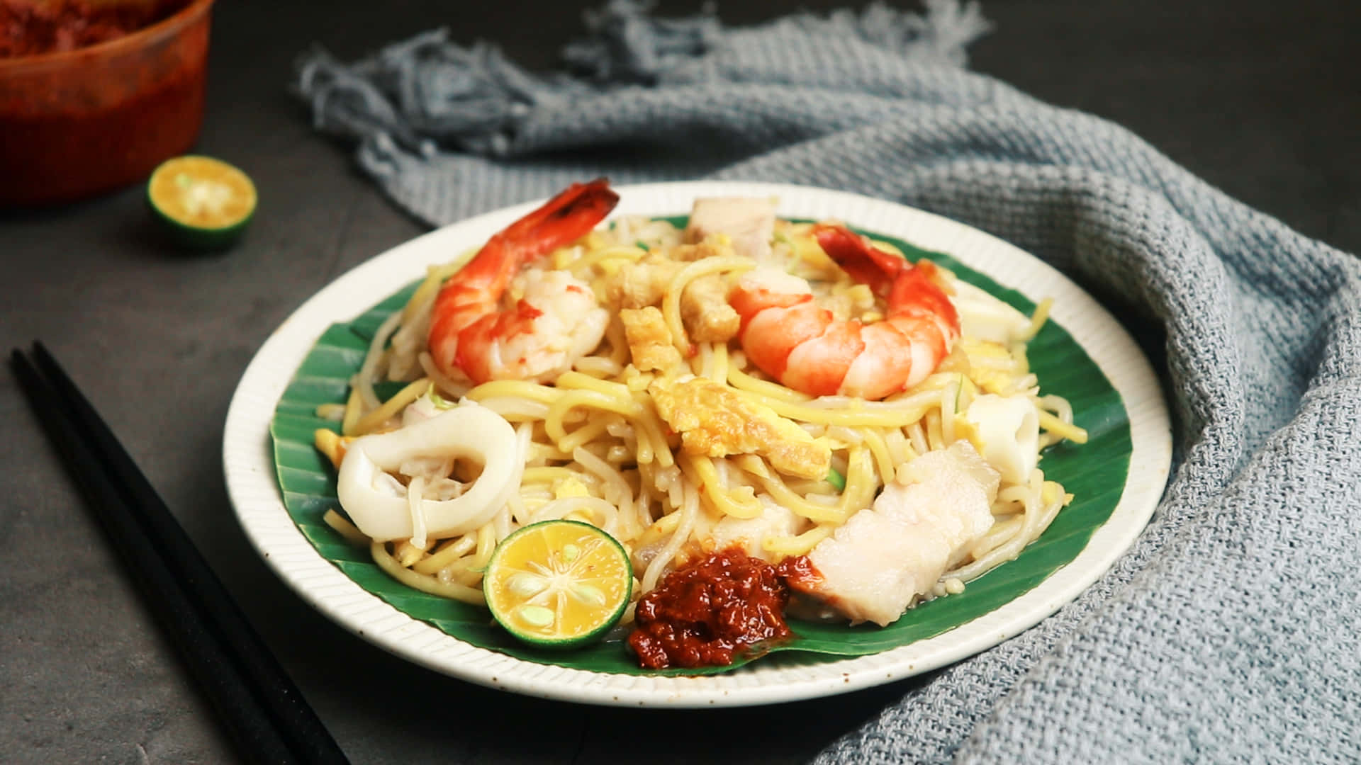 Food Photography 桌布 壁紙 — 一盤炒麵，上面放著蝦、魷魚和雞蛋，配上萊姆和辣椒醬。