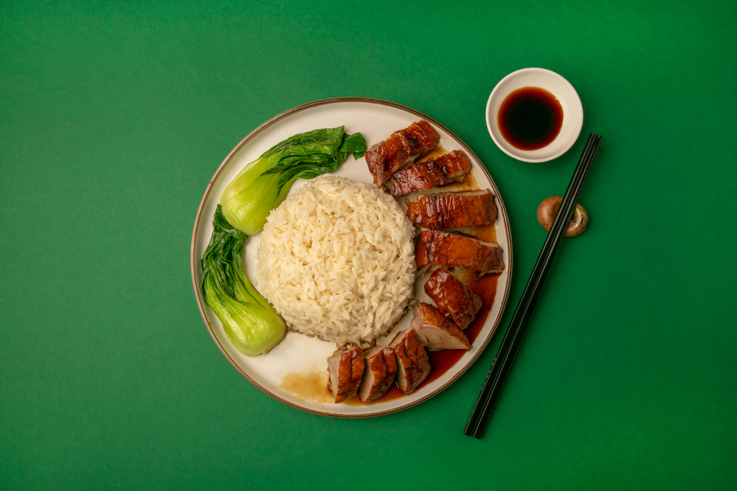 Singapore 桌布 壁紙 — 一盤烤鴨飯搭配青江菜和醬油，放在鮮綠色背景上。