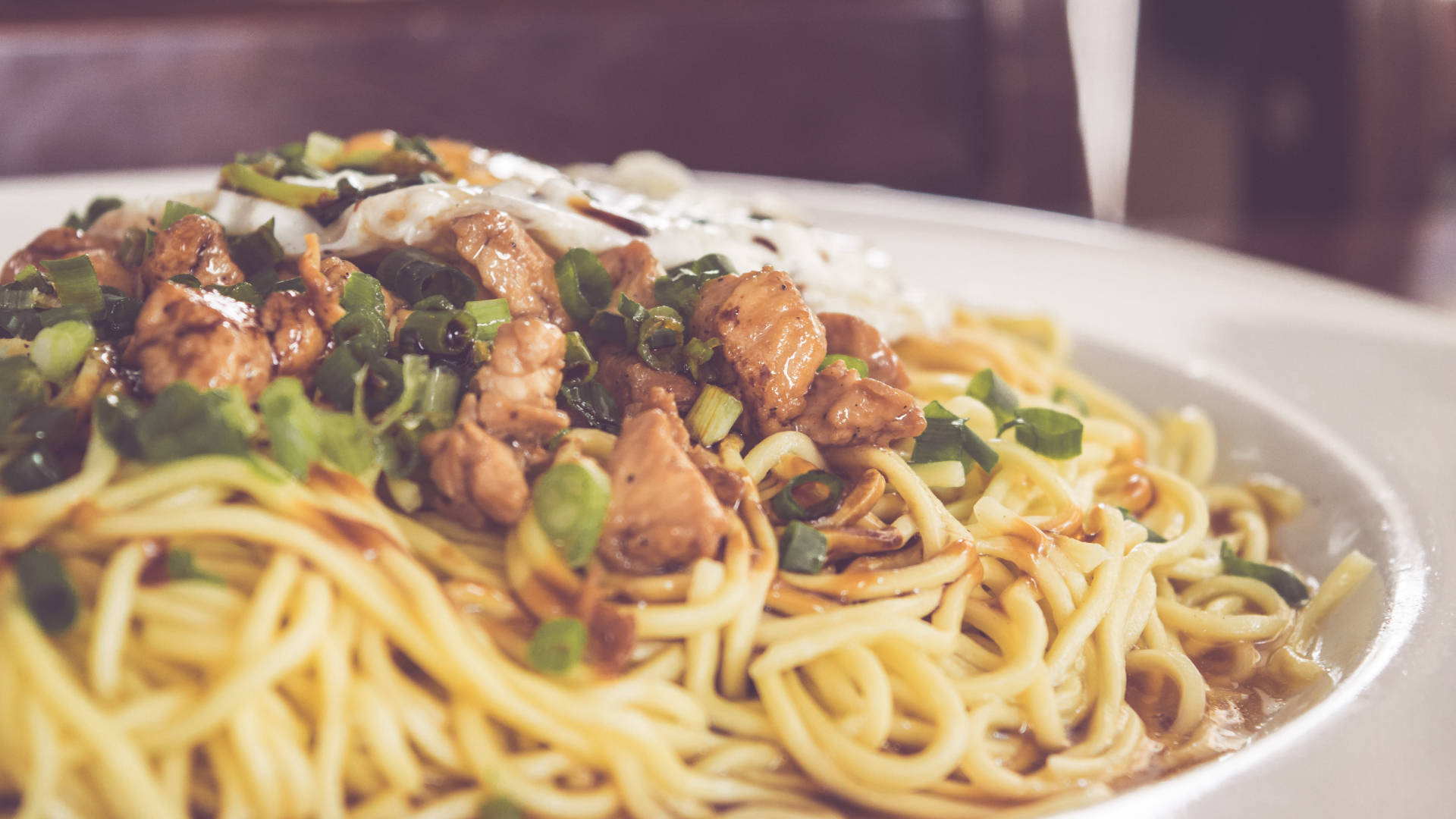 Pasta 桌布 壁紙 — 一盤熱騰騰的麵條，上面放有釉面雞肉和切碎的青蔥的特寫。