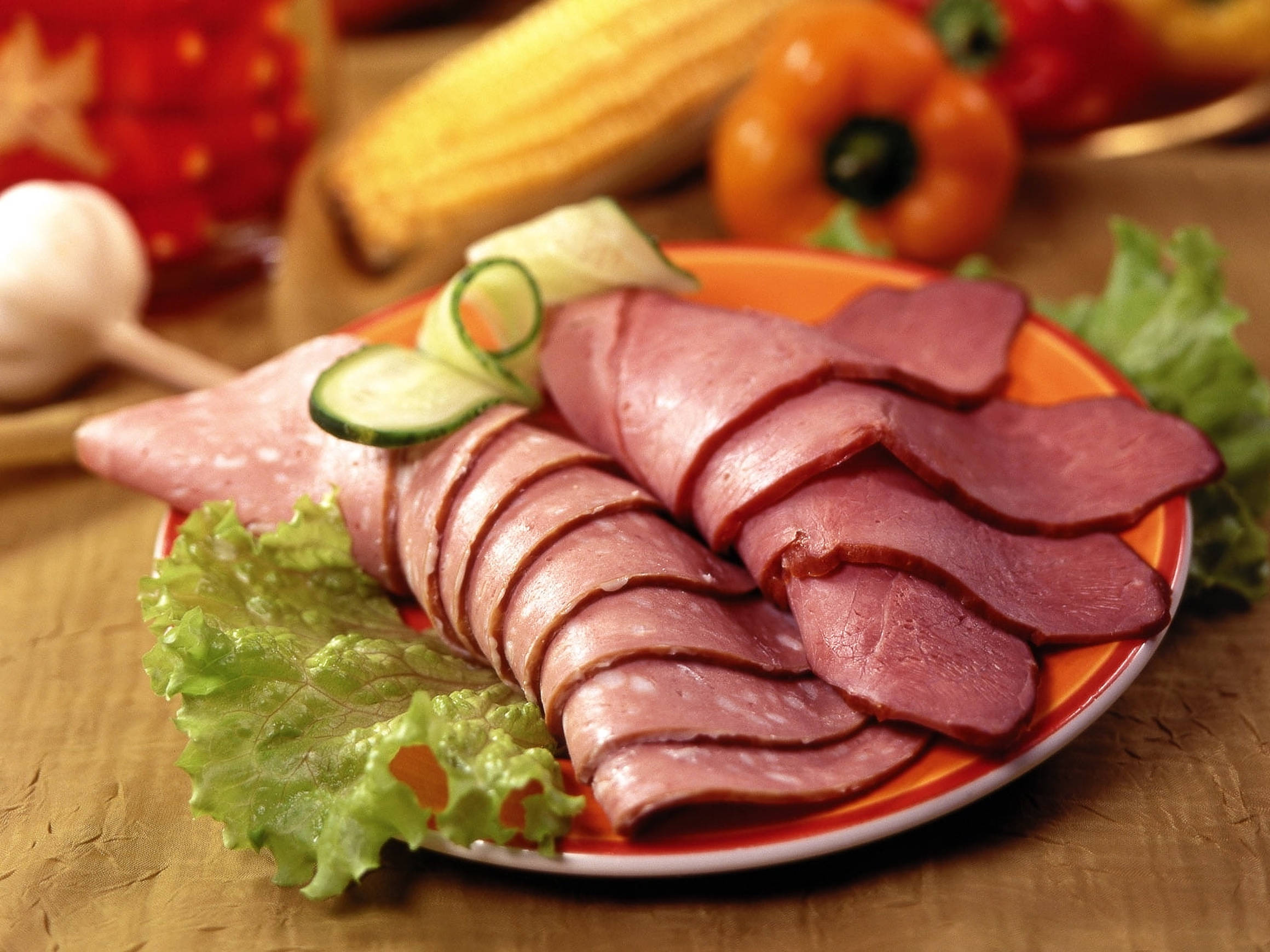 Ham 桌布 壁紙 — 一盤色彩繽紛的切片醃製肉類，飾以黃瓜和生菜，周圍是新鮮蔬菜。