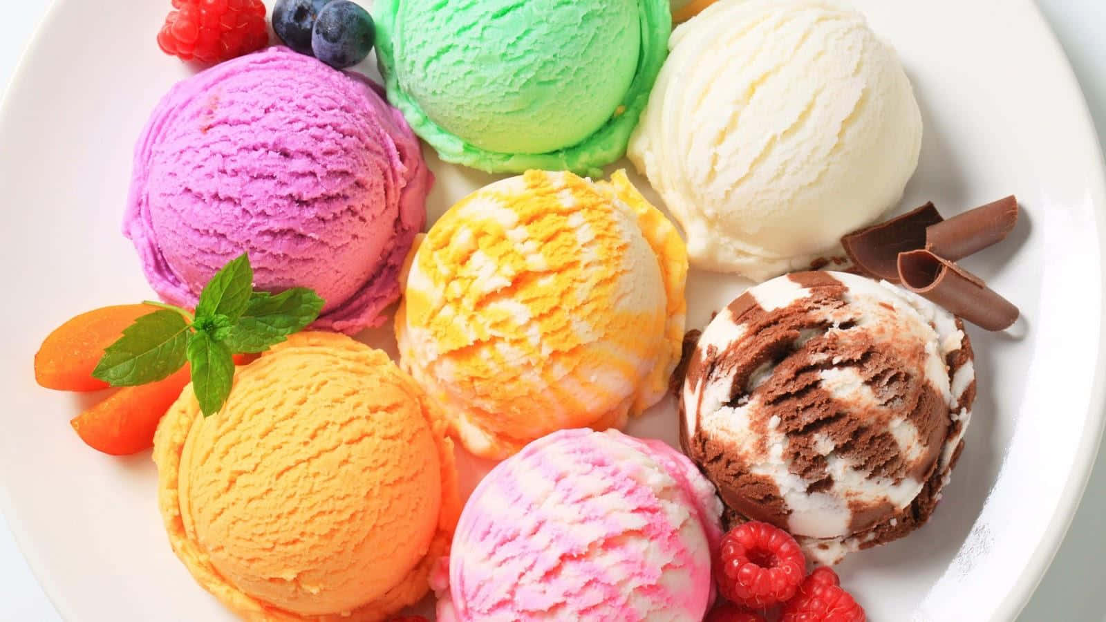 Ice Cream 桌布 壁紙 — 一盤色彩繽紛的各式冰淇淋球，配上新鮮莓果和薄荷裝飾。
