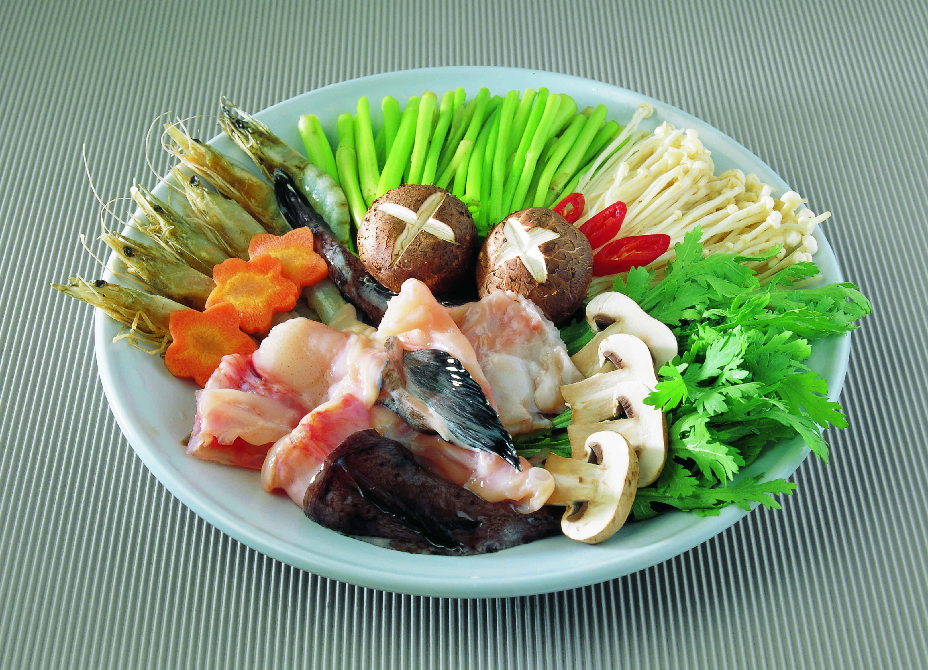 Healthy Food 桌布 壁紙 — 一盤色彩繽紛的各式生海鮮和蔬菜，整齊排列用於火鍋，放在條紋桌墊上。