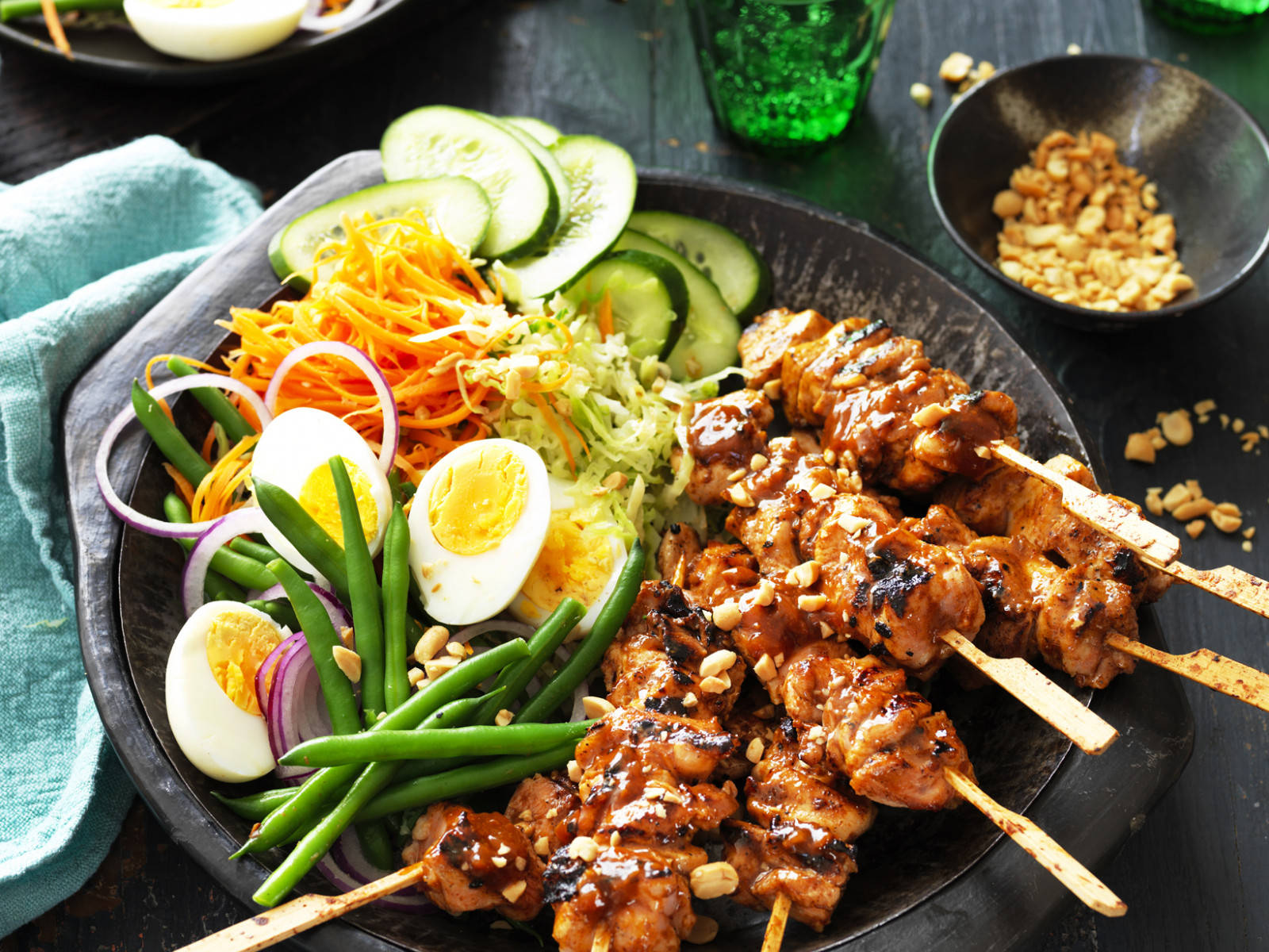 Delicious Food 桌布 壁紙 — 一盤色彩繽紛的烤雞沙爹串，塗上醬汁，配上新鮮黃瓜、胡蘿蔔、豆芽和水煮蛋裝飾。
