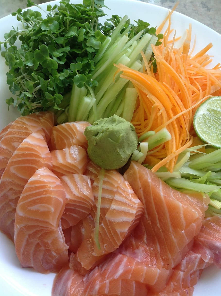 Salmon 桌布 壁紙 — 一盤色彩鮮豔的新鮮鮭魚生魚片，飾以微型蔬菜、刨絲紅蘿蔔和萊姆角。