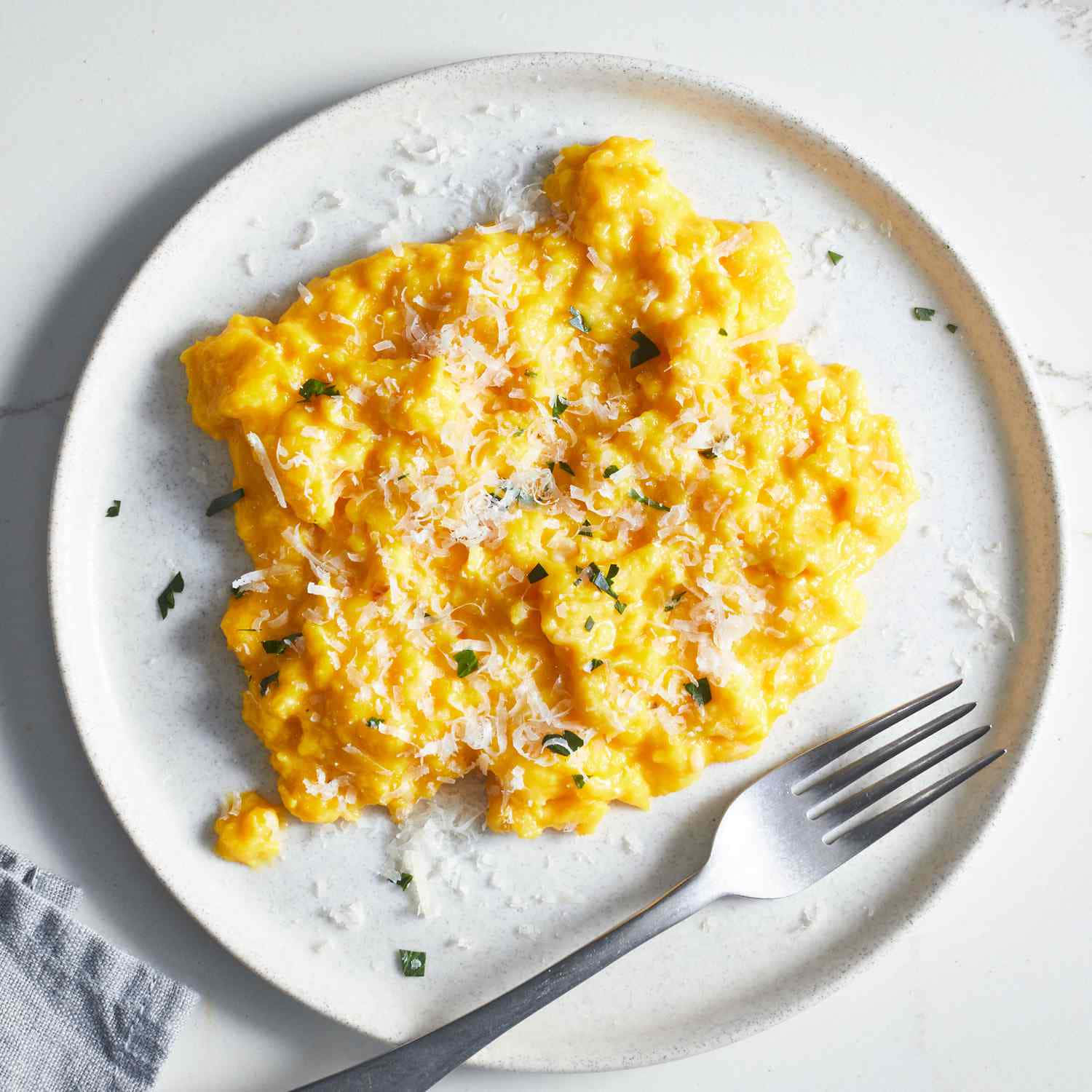 Scrambled Egg 桌布 壁紙 — 一盤蓬鬆的黃色炒蛋，上面撒有磨碎的起司和新鮮香草。
